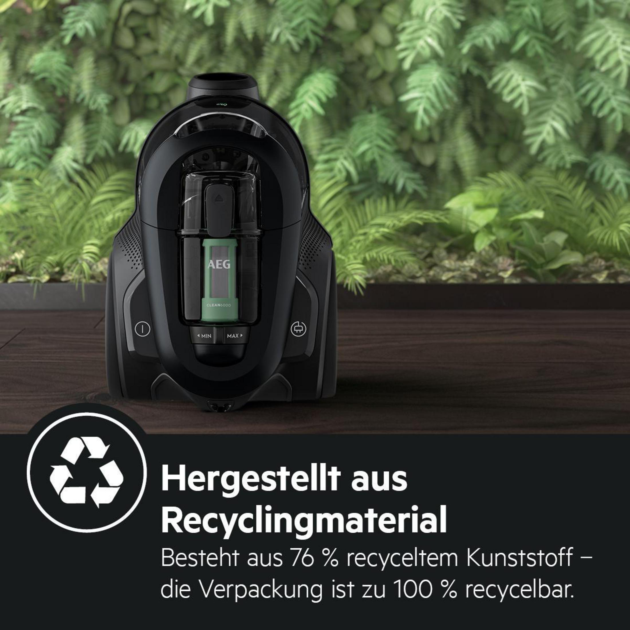 Czarny odkurzacz z zielonym filtrem. Stoi na drewnianym stole.