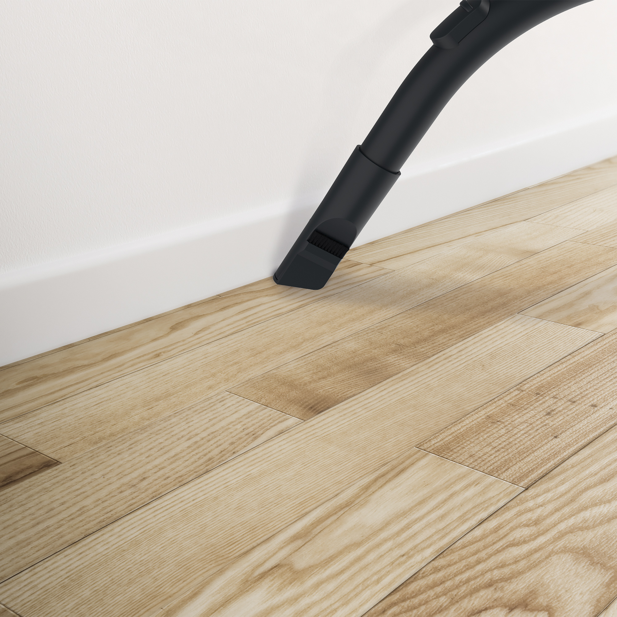 Dysza odkurzacza na jasnej drewnianej podłodze, blisko białej ściany i listwy przypodłogowej.