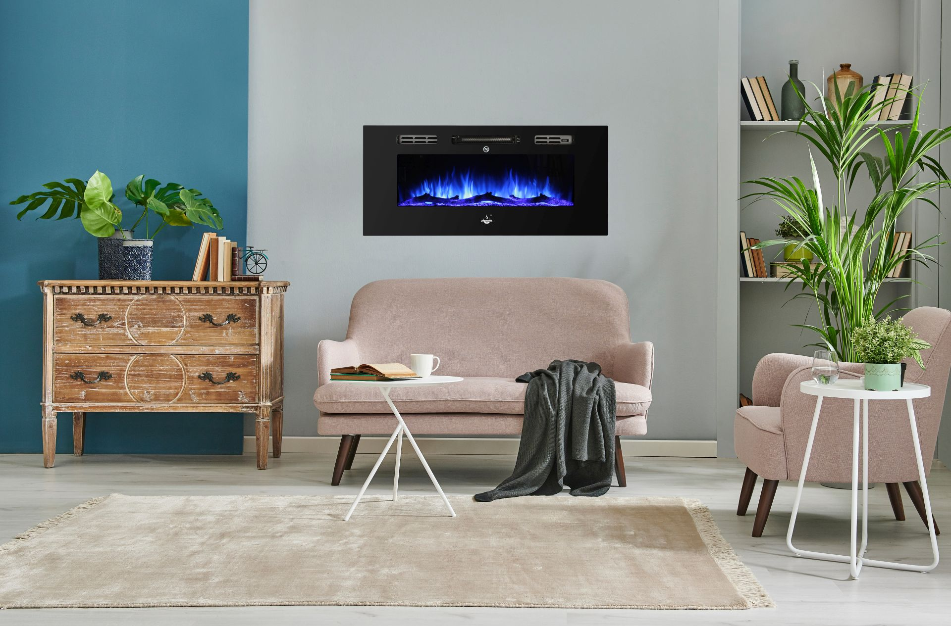 Wohnzimmer mit Kamin, Sofa und Beistelltisch. Blaue Flammen im Kamin. Pflanzen und Bücher sind ebenfalls sichtbar.