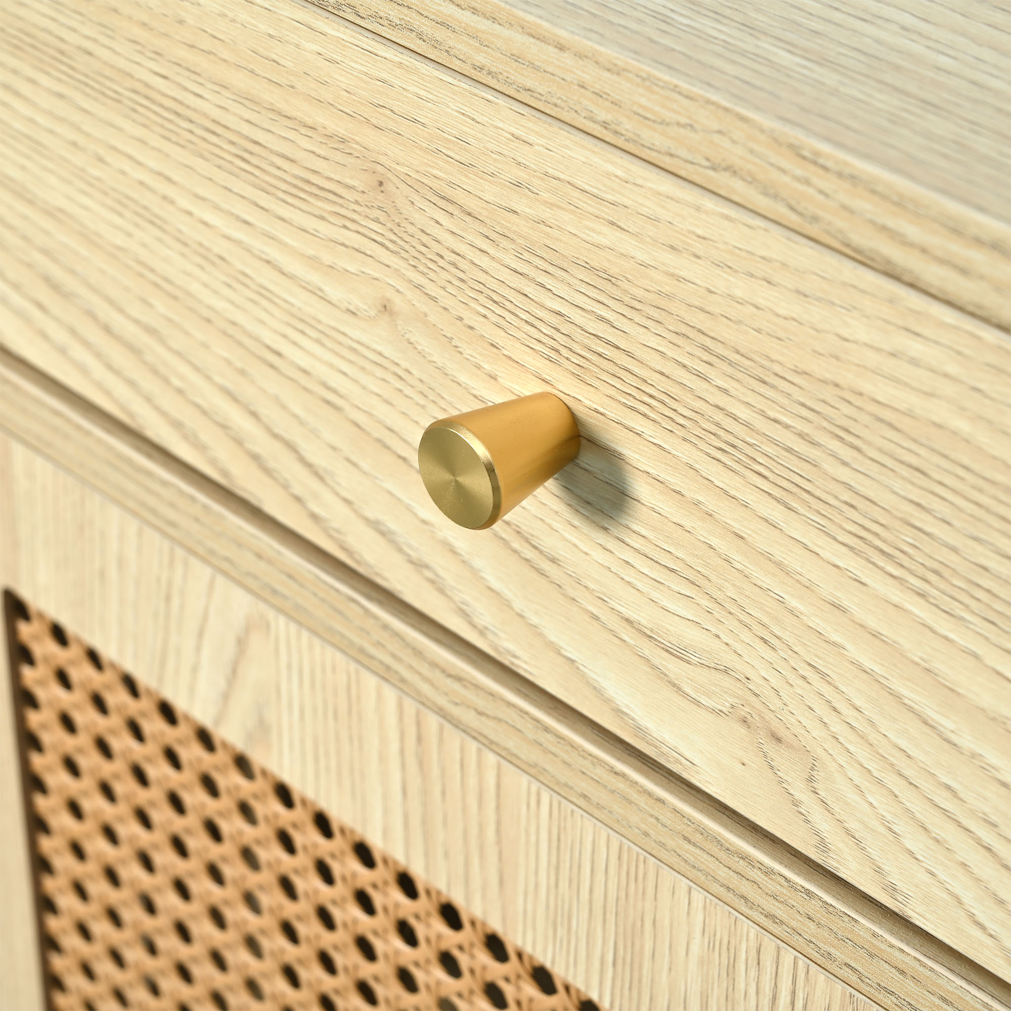 Nahaufnahme einer Holzschublade mit einem goldenen Knopf. Hellbraune Holzmaserung.