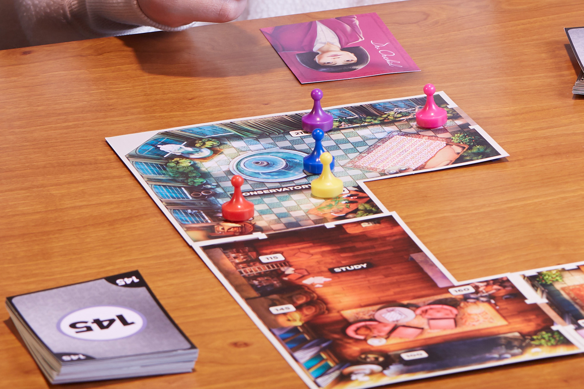 Ein Brettspiel-Setup mit Spielfiguren und Karten auf einem Holztisch, Draufsicht.