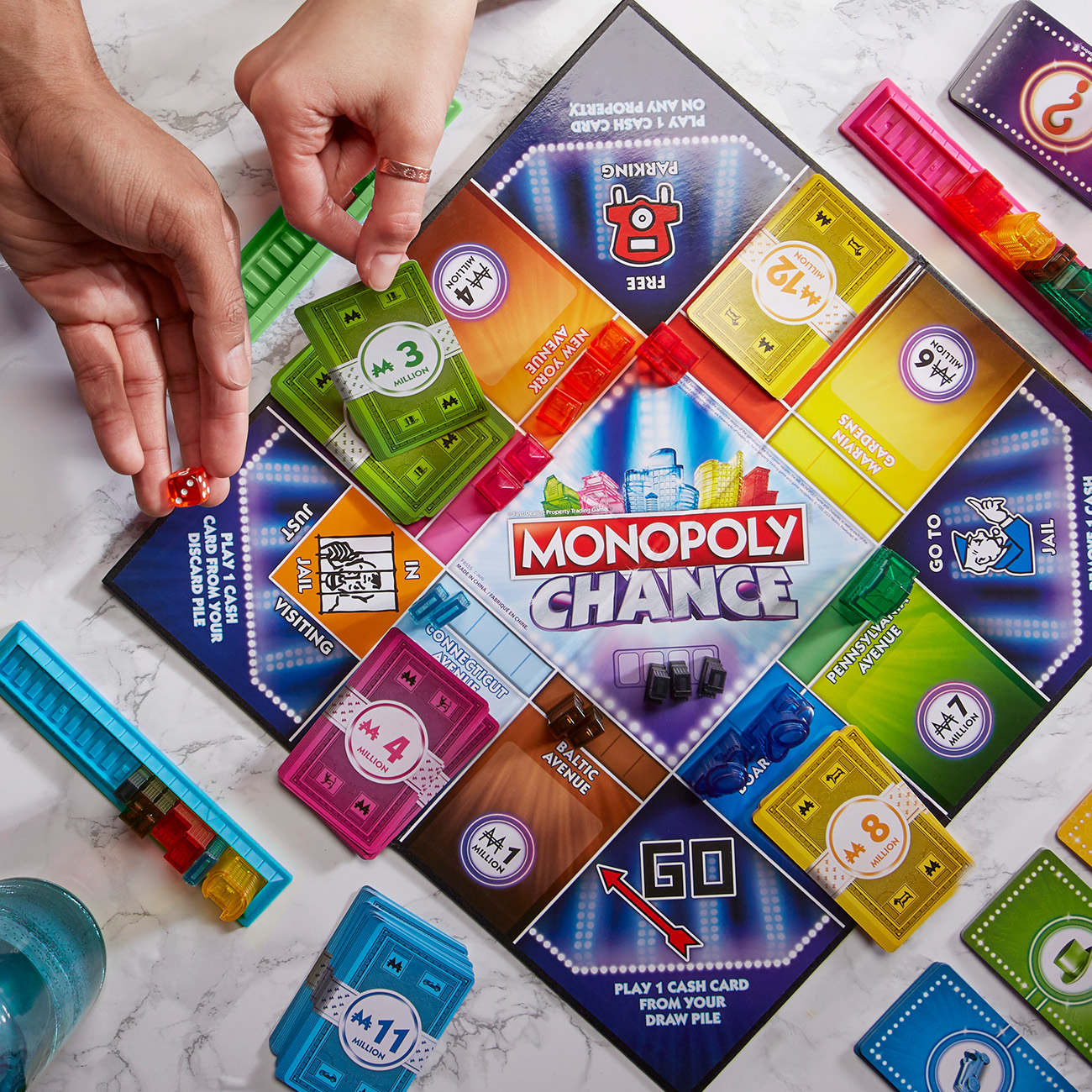 Monopoly-Brettspiel im Spiel. Hände bewegen Spielfiguren, Karten und Würfel auf dem Brett.