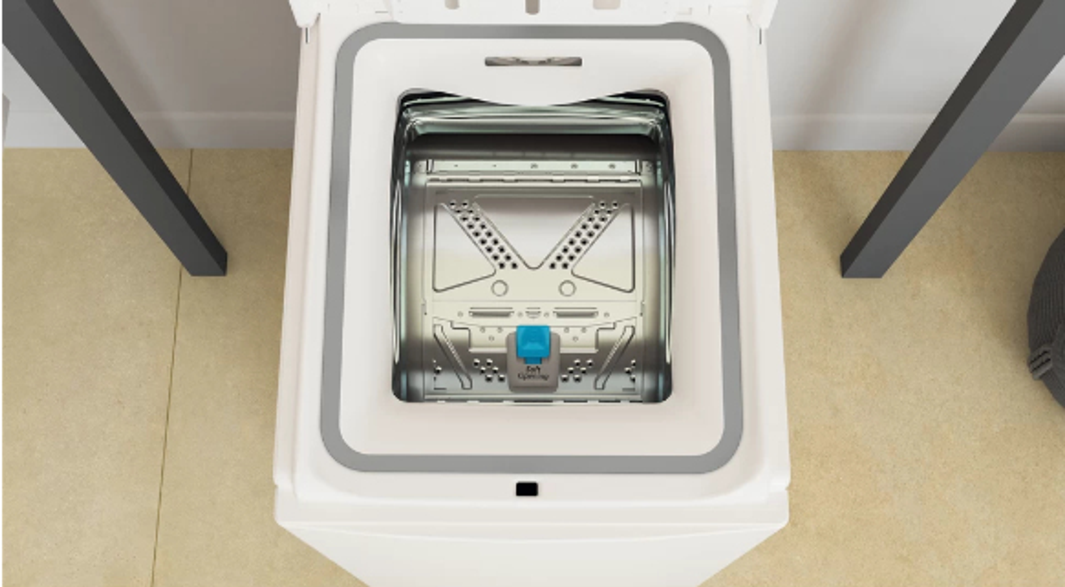 Widok z góry na otwarty bęben białej pralki, z niebieskim elementem.