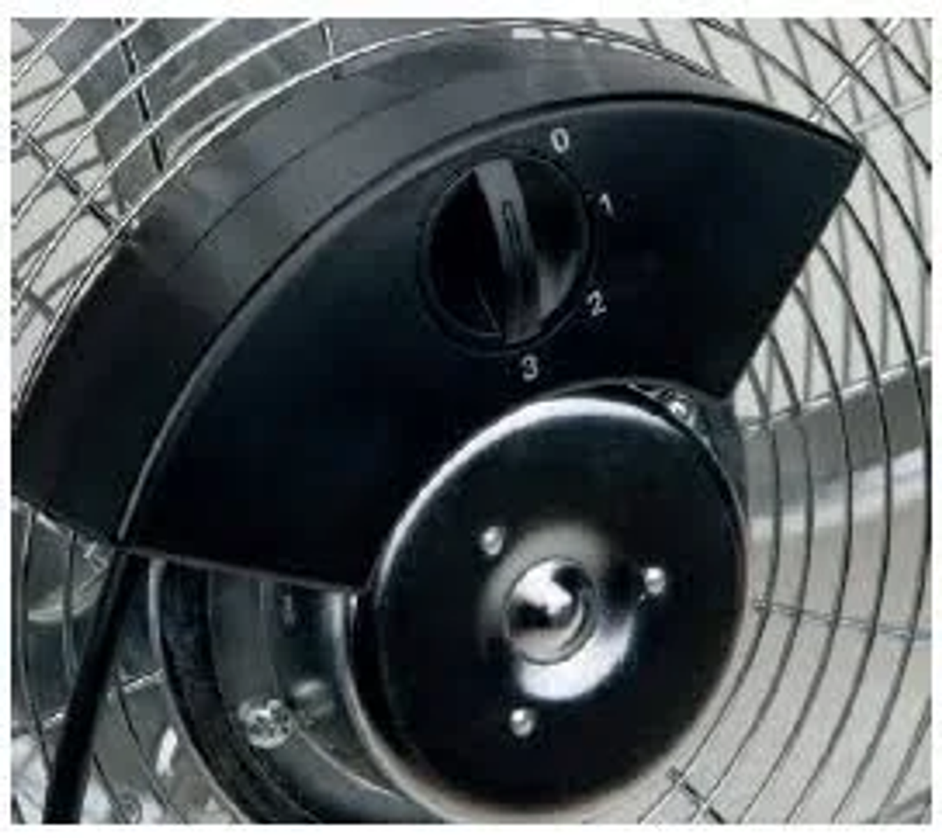 Primer plano del control de velocidad de un ventilador. Panel de control negro. Fondo de malla metálica.