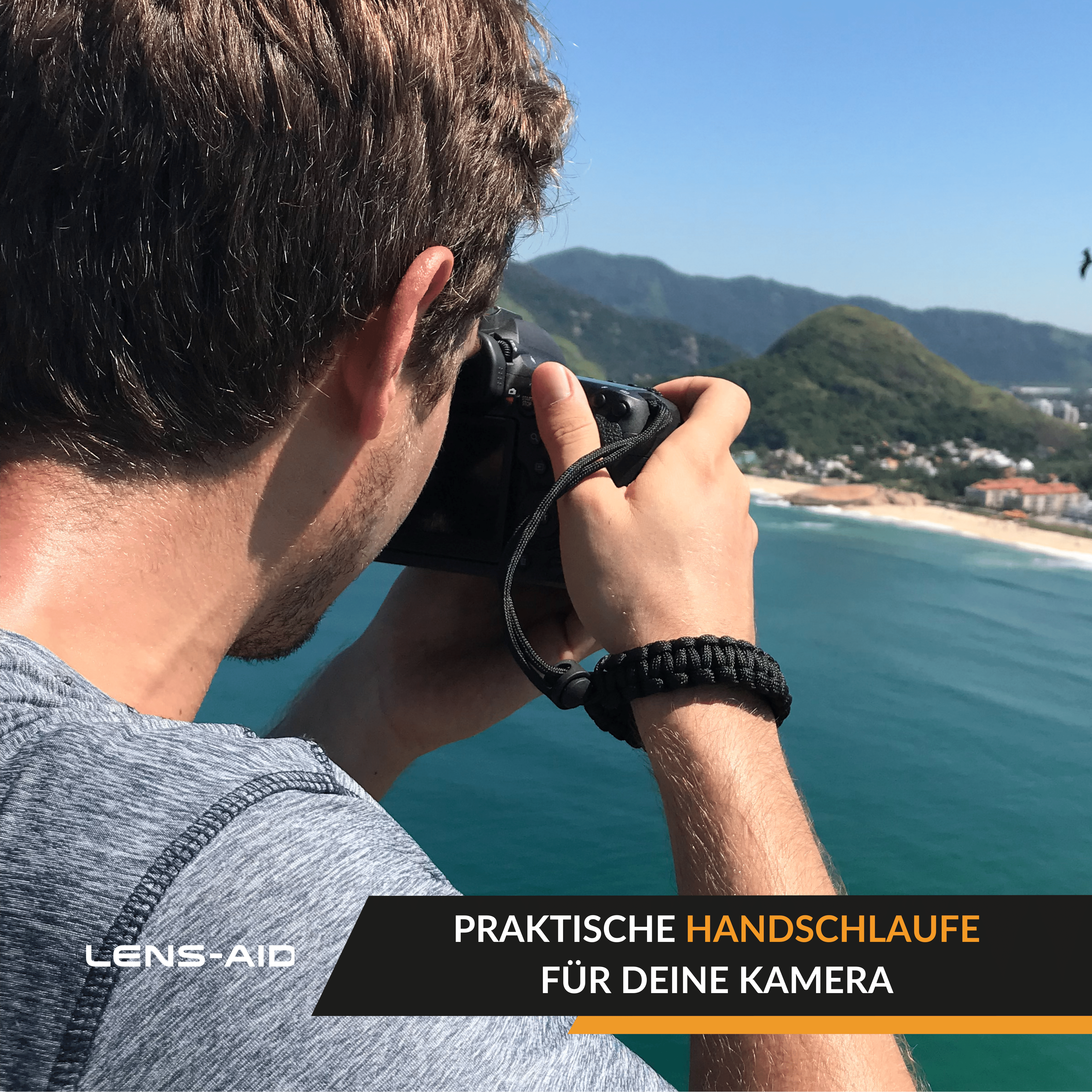 Mann, der mit einer schwarzen Kamera fotografiert, Armband tragend, mit Blick auf einen Strand.