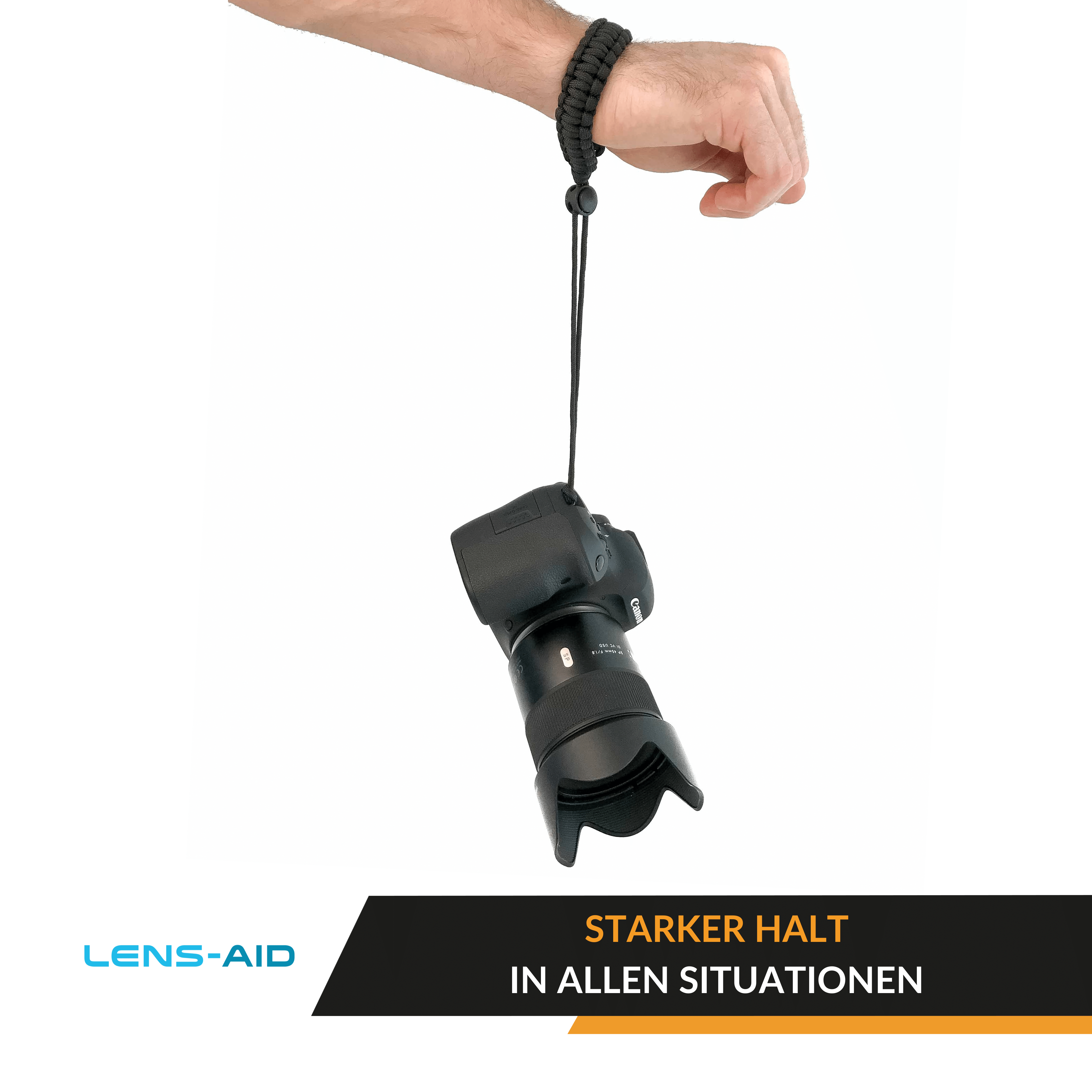 Eine schwarze Kamera hängt an einer schwarzen Handschlaufe, die von der Hand einer Person gehalten wird.
