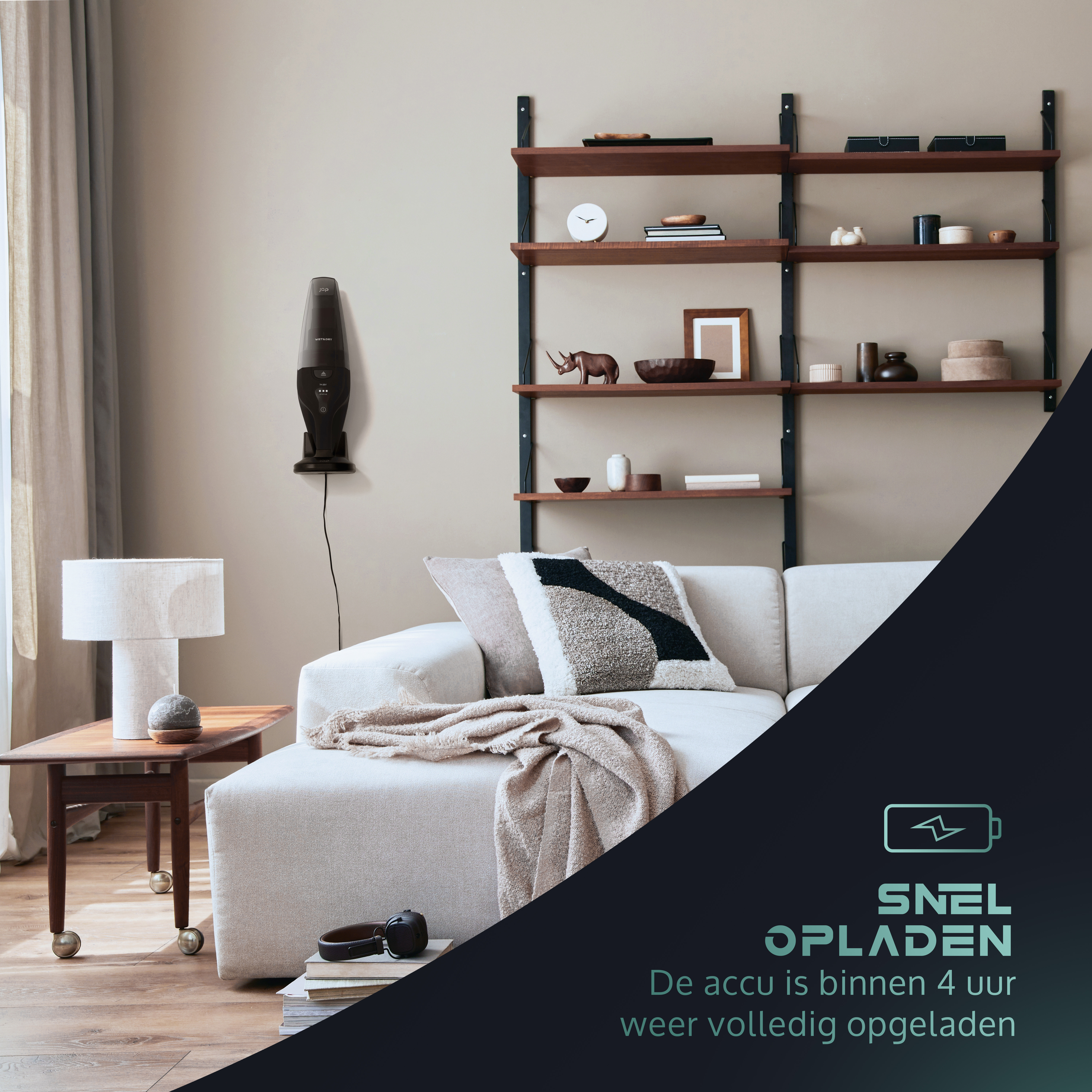 Schwarzer Staubsauger an der Wand. Sofa, Regale, Tisch und Fenster im Hintergrund.