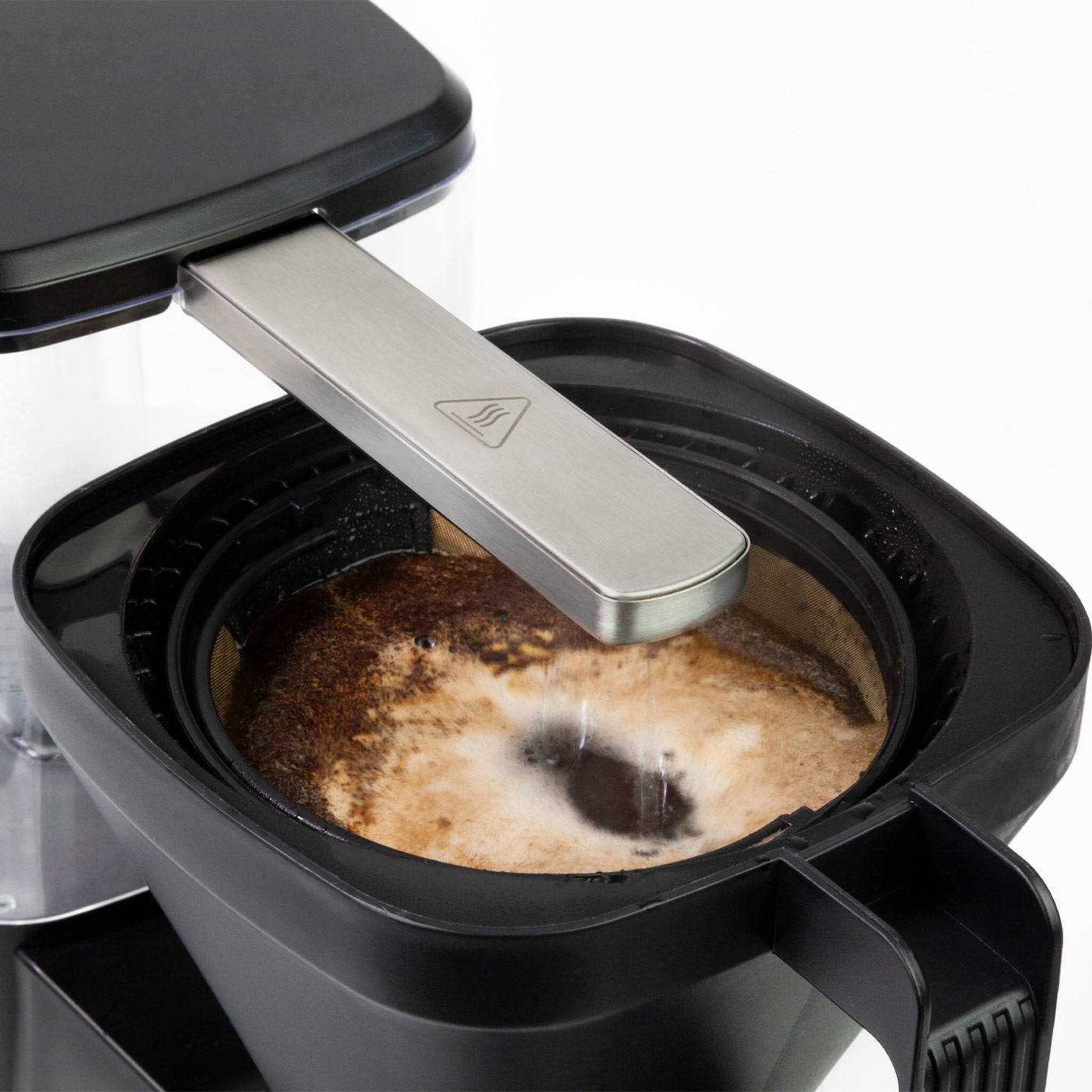 Kaffeemaschine mit geöffnetem Filterhalter, Kaffeesatz im Filter sichtbar, auf weißem Hintergrund.