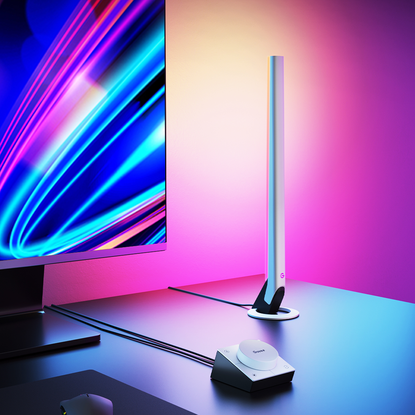 Eine Schreibtischlampe mit hohem, silbernen Körper steht neben einem Computermonitor, mit einem Bedienfeld.