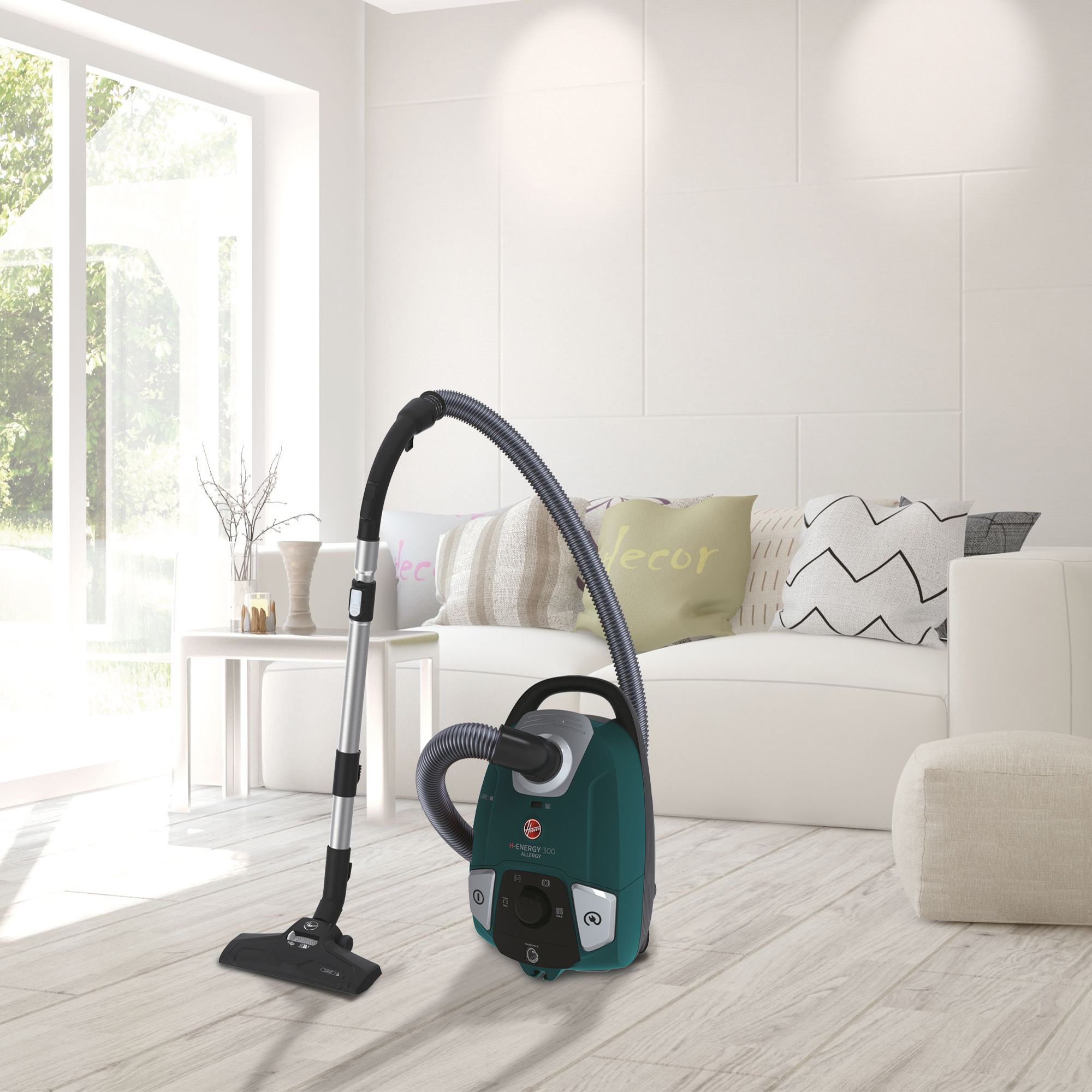 Turkusowy odkurzacz z wężem, w salonie.