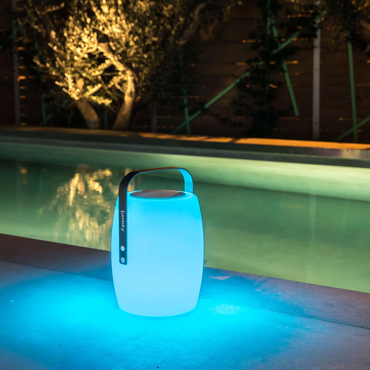 Eine blau leuchtende Außenlampe neben einem Pool. Die Lampe hat einen schwarzen Griff und eine Holzplatte.