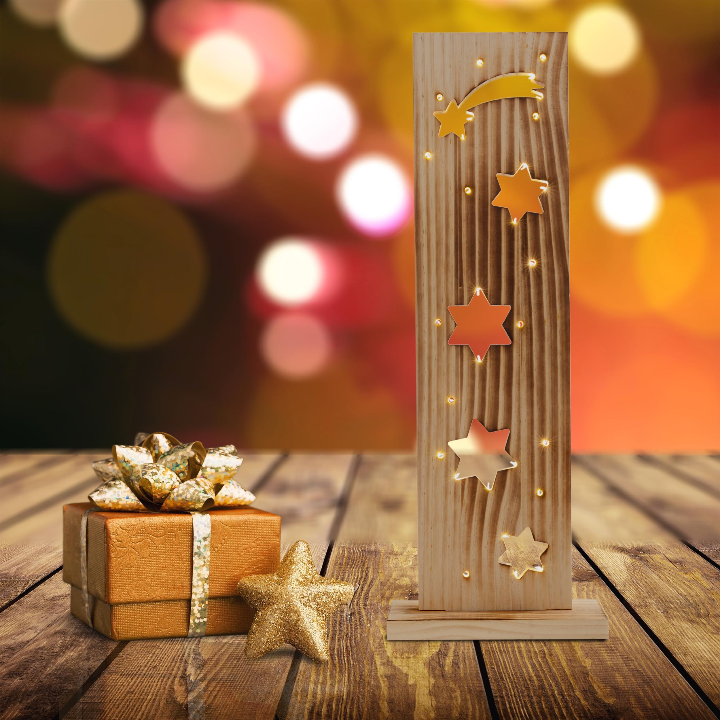 Weihnachtsdeko aus Holz mit Sternen und Geschenkbox. Hintergrund hat verschwommene Lichter.
