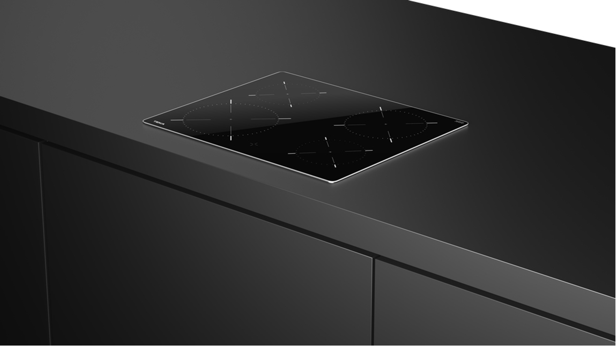 Czarna płyta grzewcza na czarnym blacie.