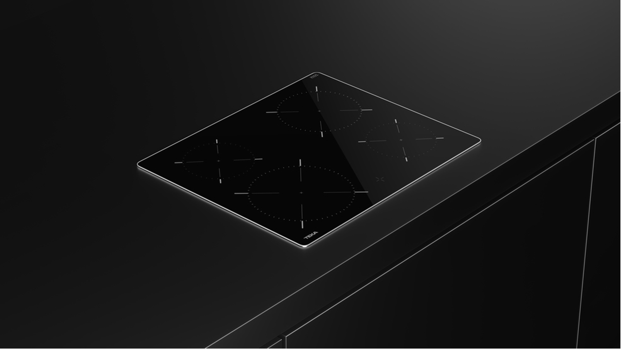 Czarna płyta grzewcza z czterema strefami gotowania na czarnym blacie.