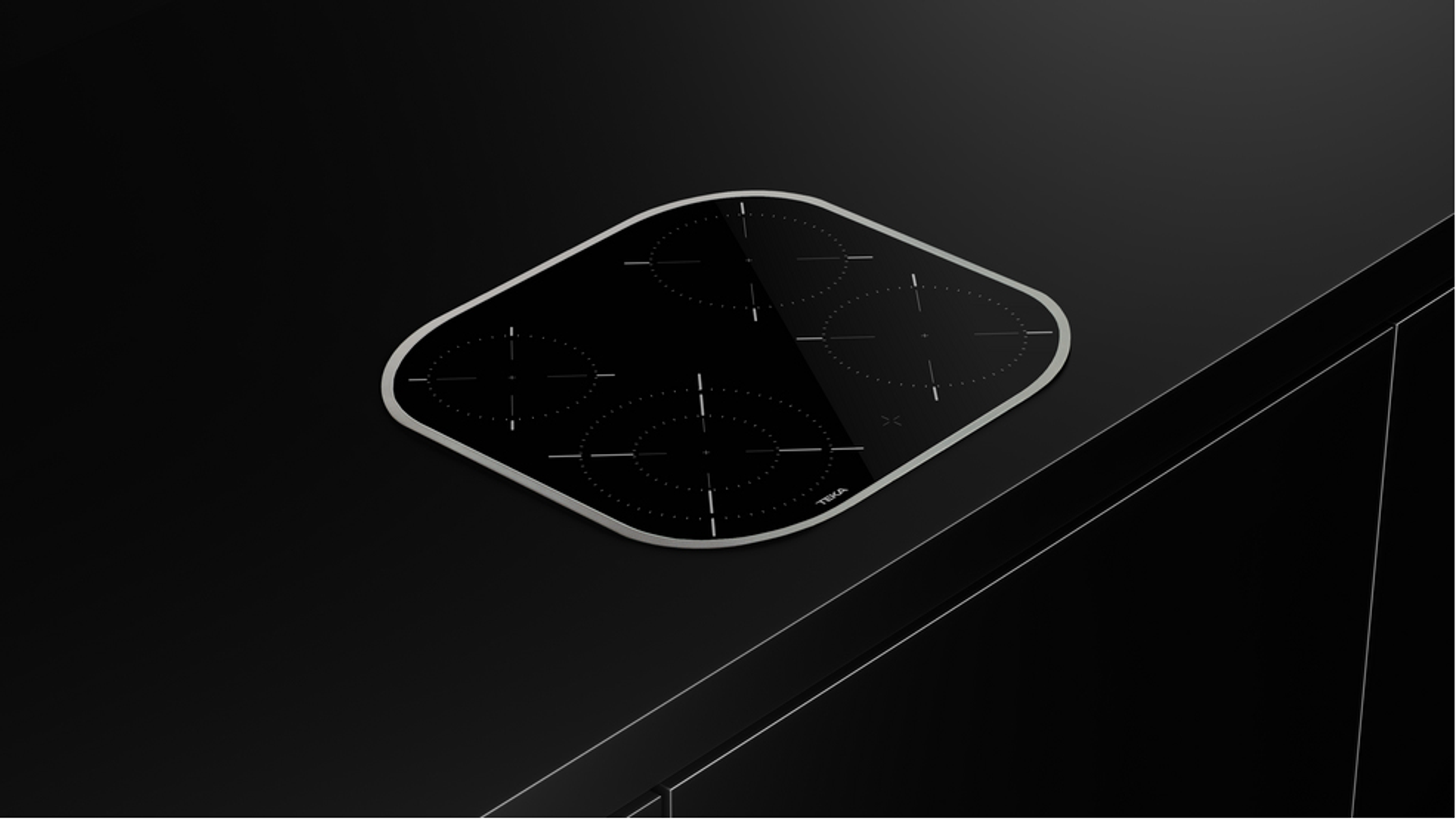 Czarna, w kształcie rombu płyta grzewcza z czterema palnikami i logo TEKA na ciemnym tle.