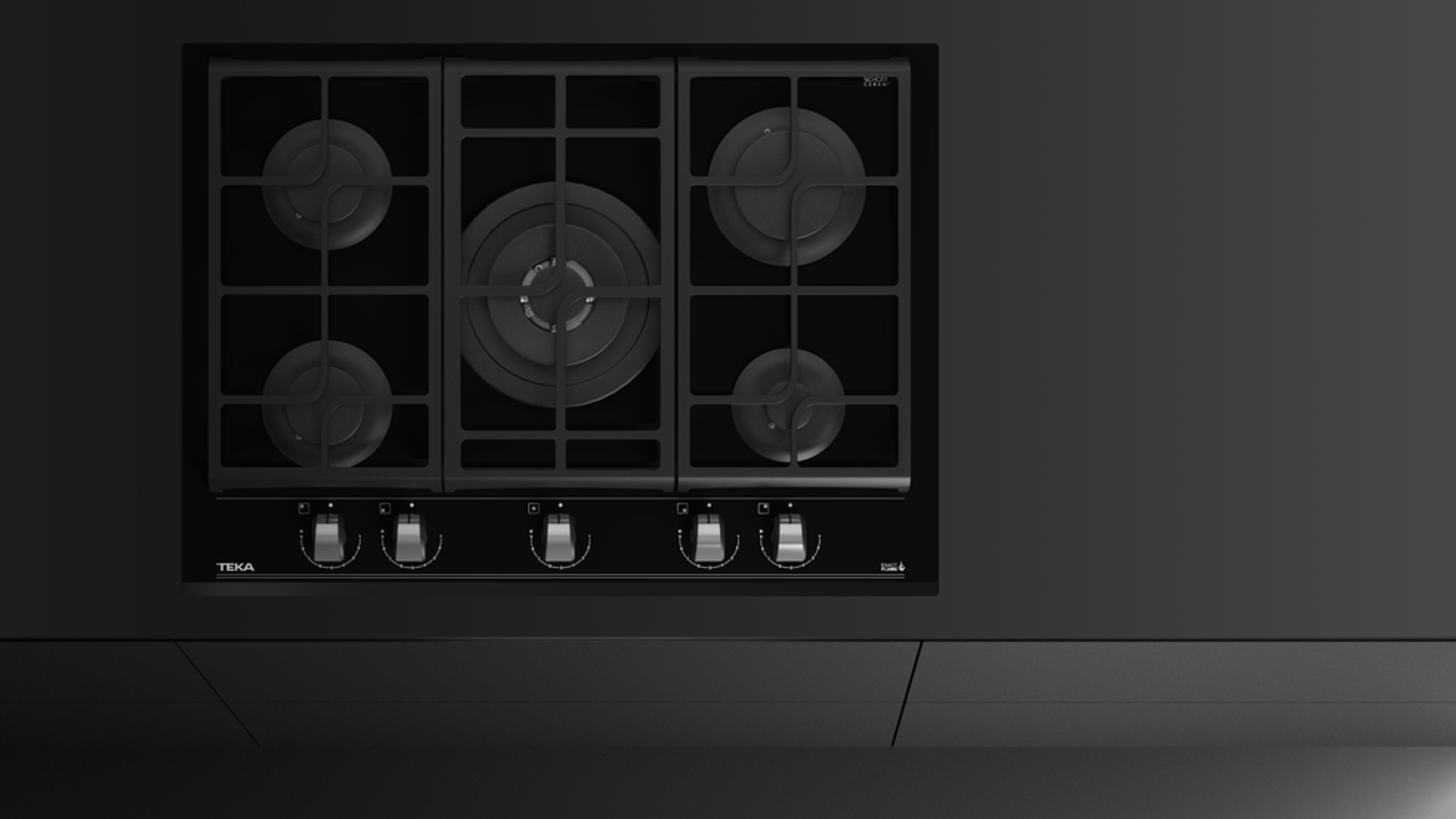 Czarna płyta grzejna z pięcioma palnikami, osadzona w czarnym blacie.