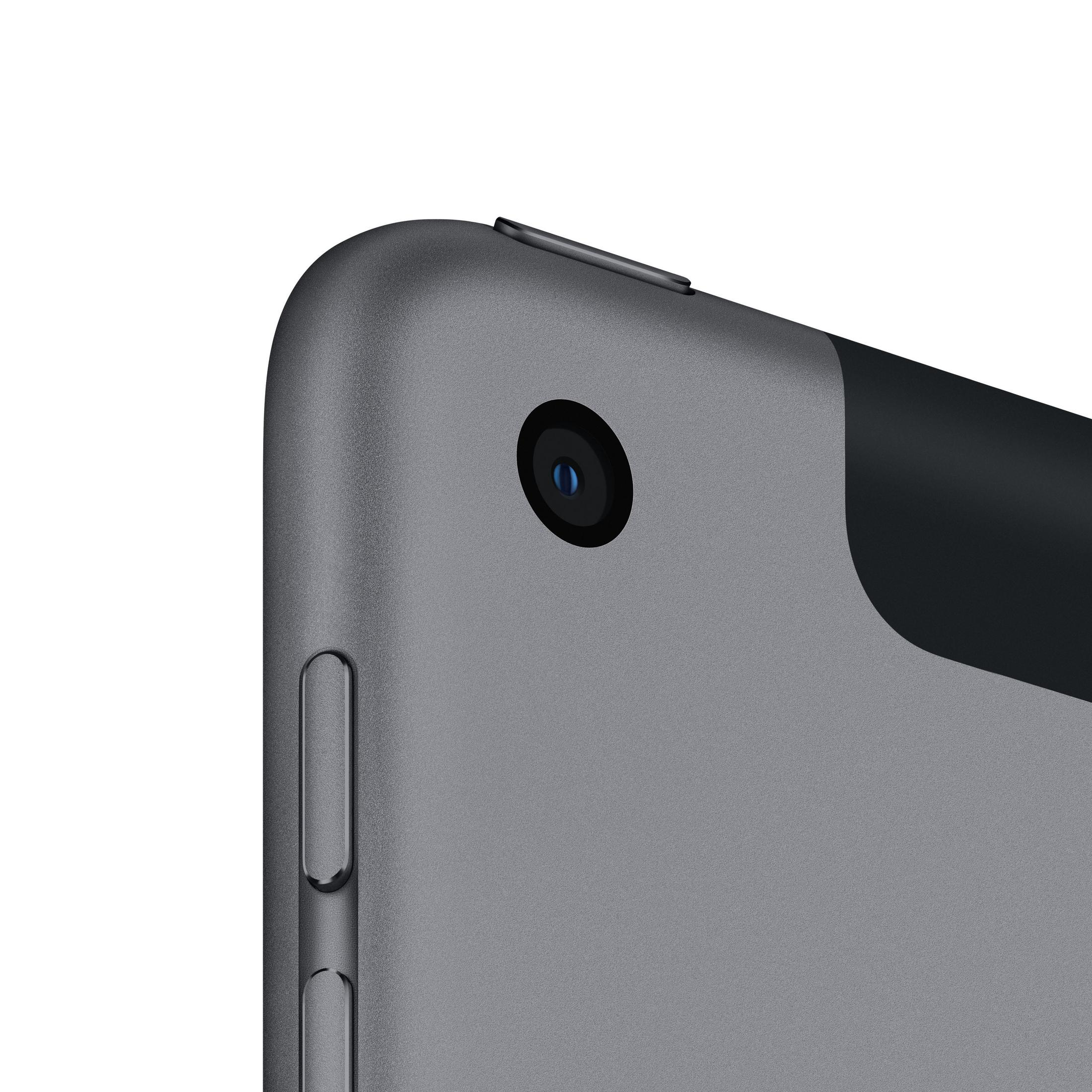 Zbliżenie rogu szarego tabletu z obiektywem aparatu na białym tle.