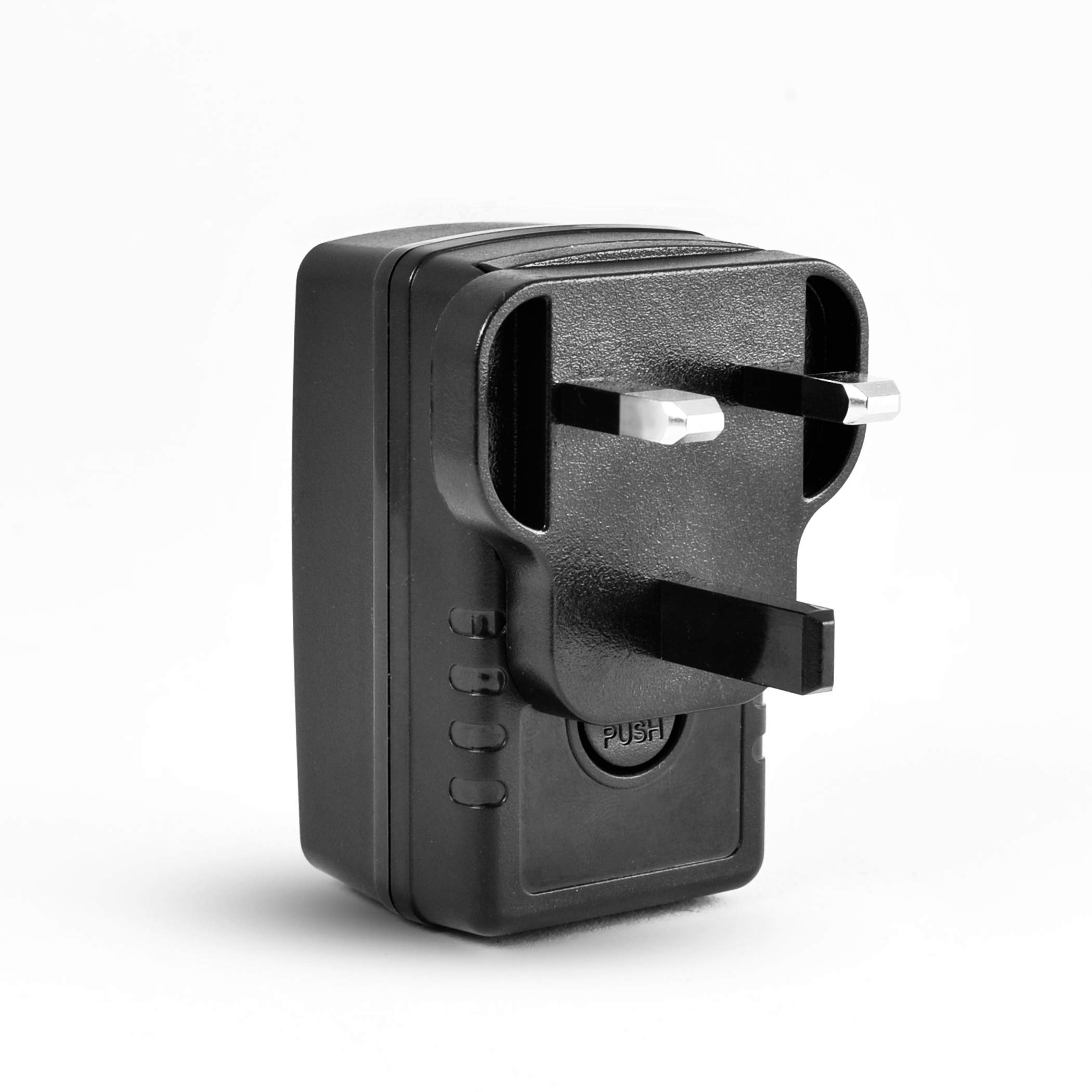 Schwarzer Reiseadapter. Er hat drei Stifte und einen 'PUSH'-Knopf. Weißer Hintergrund.