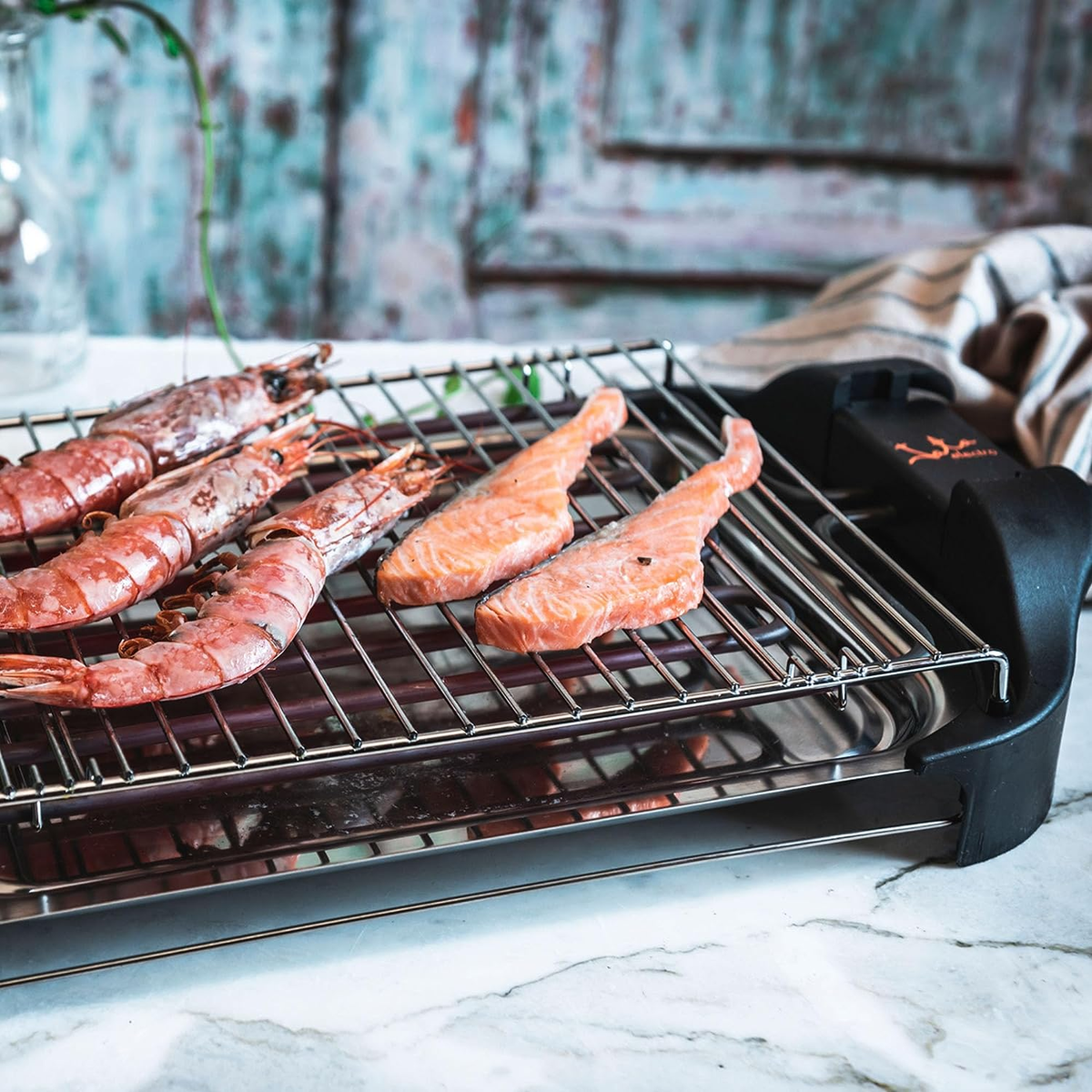 Griglia con gamberi e salmone. Sfondo mostra un muro di legno.