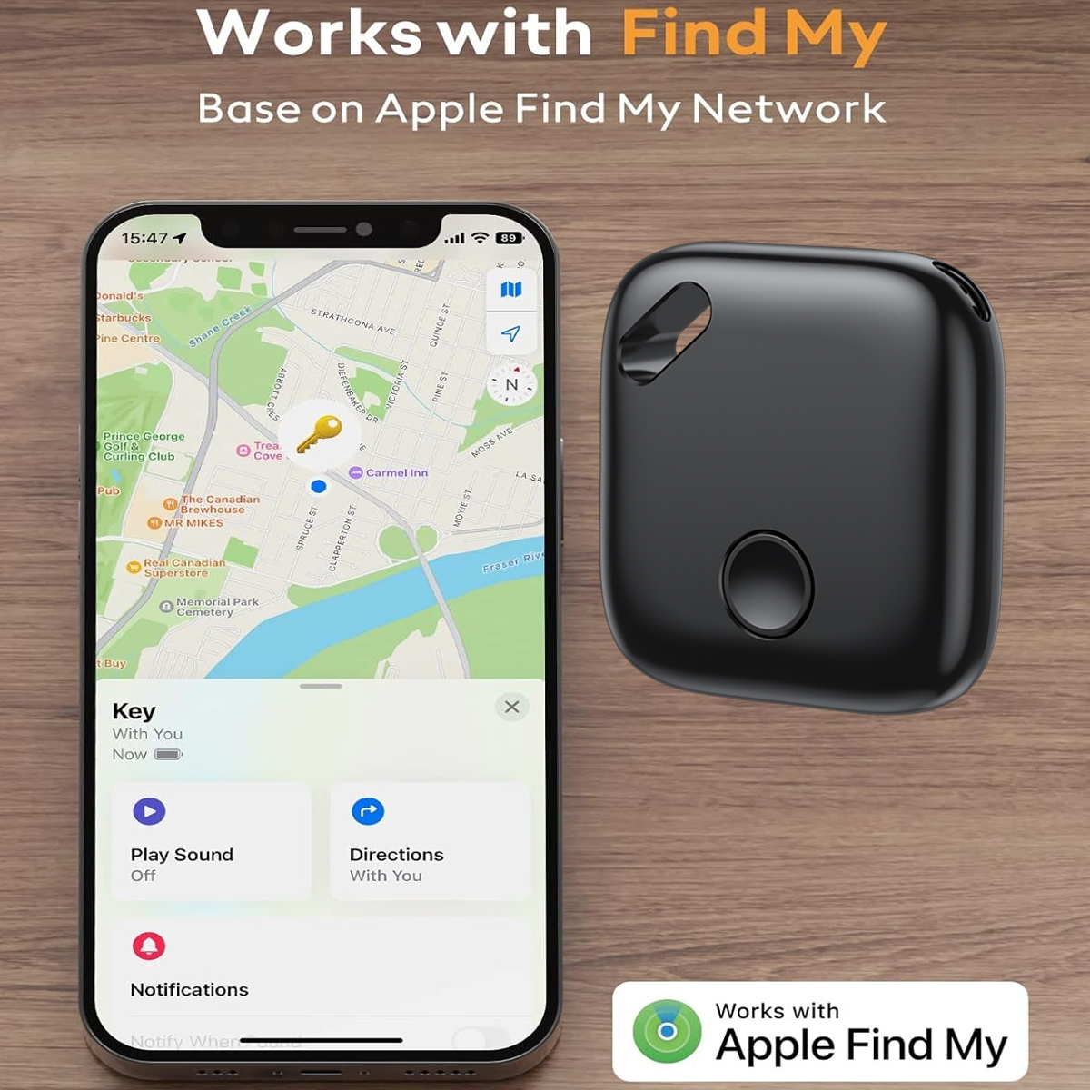 Ein schwarzer Apple AirTag und ein Smartphone, das eine Karte mit einem Schlüsselsymbol zeigt. Holz Hintergrund.