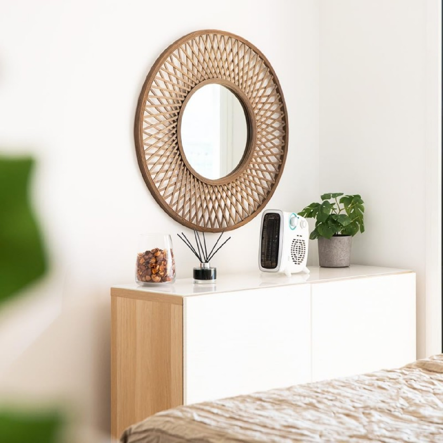 Scena wnętrza z lustrem, rośliną i białą szafką z dekoracjami.