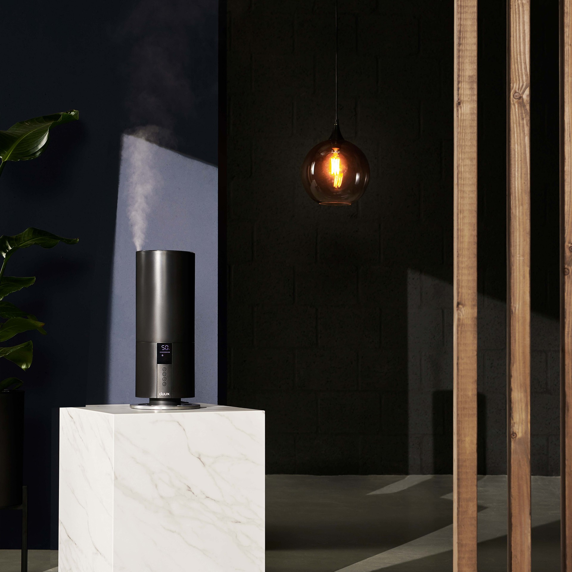 Czarny nawilżacz na białej powierzchni. Ciemnoniebieskie i czarne tło.