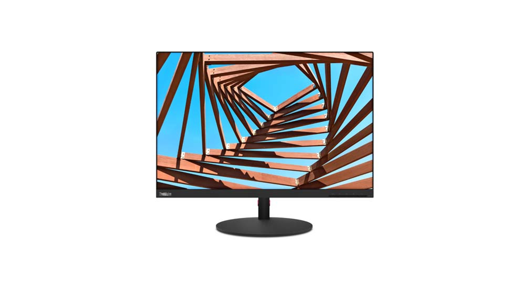 Monitor de computadora que muestra una estructura de madera contra un cielo azul, sobre una superficie blanca.