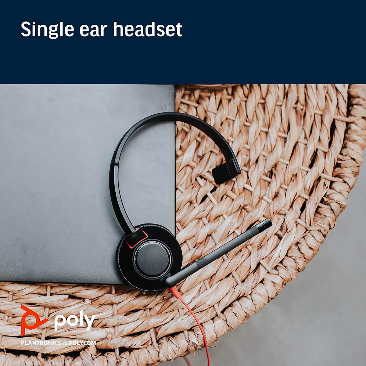 Zestaw słuchawkowy na jedno ucho na tkanej powierzchni obok laptopa.