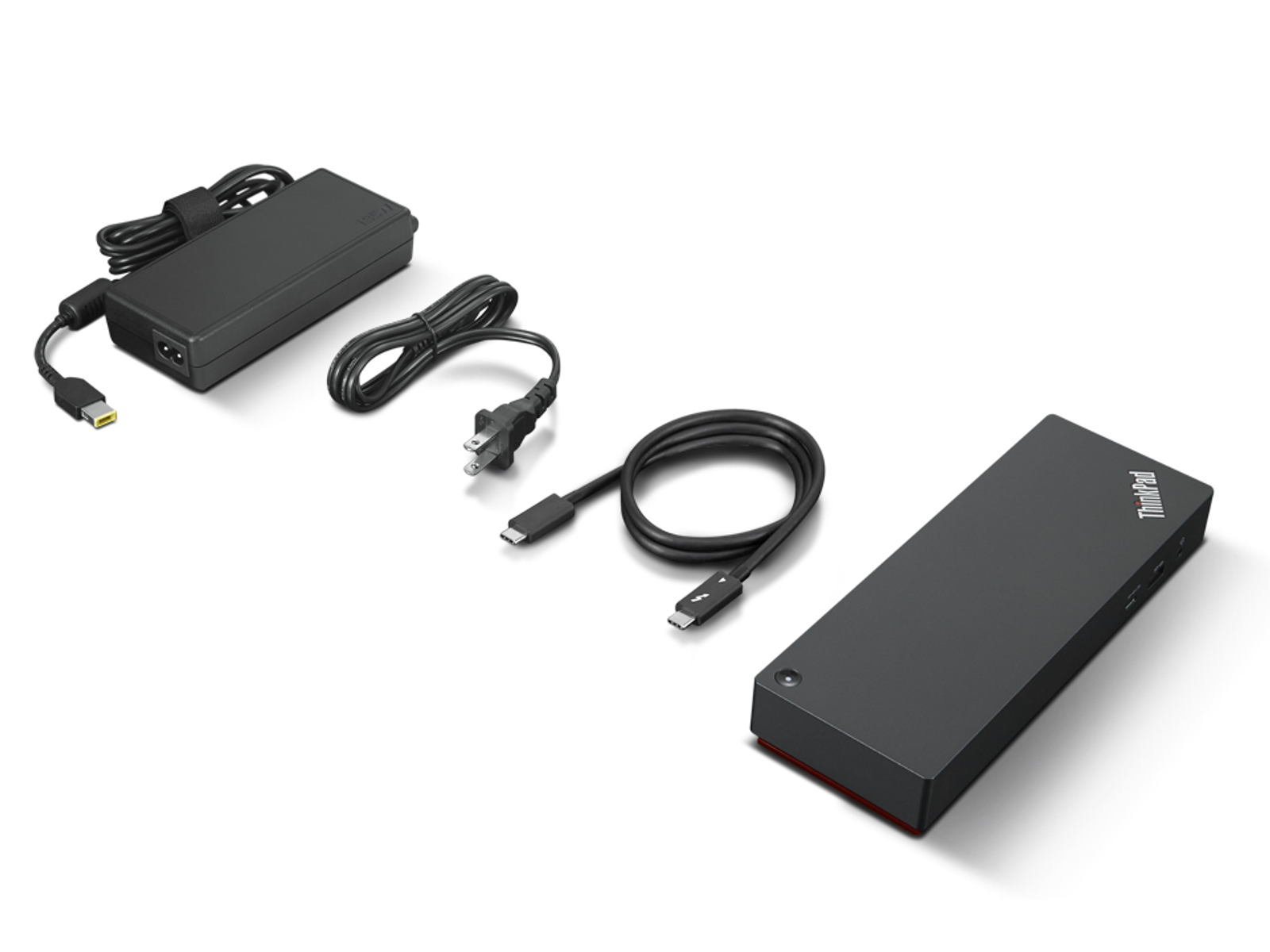 Ein schwarzes ThinkPad-Dock mit Netzteil und Verbindungskabeln, weißer Hintergrund.