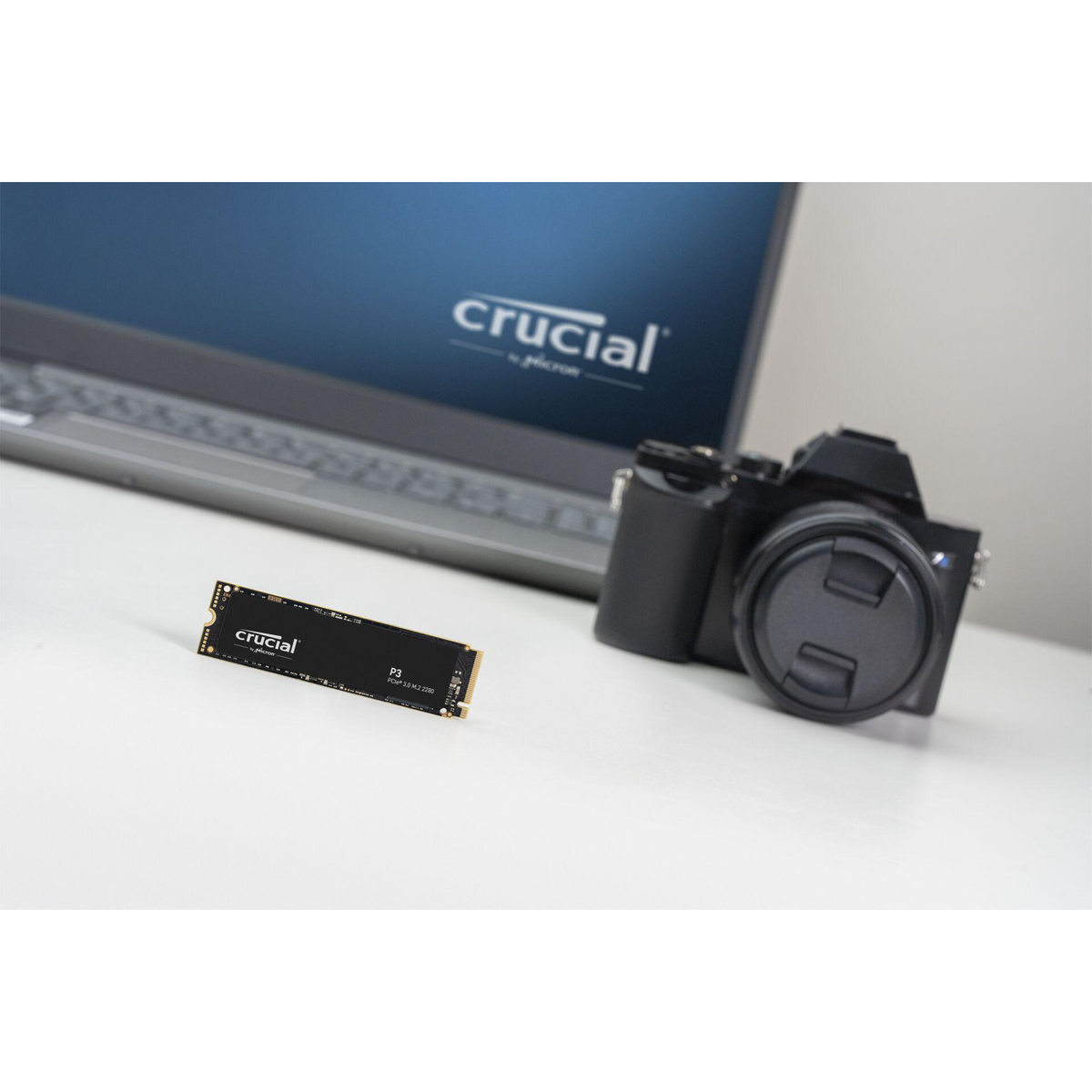 SSD en camera in een opname. Crucial SSD, camera en laptop op een wit oppervlak.