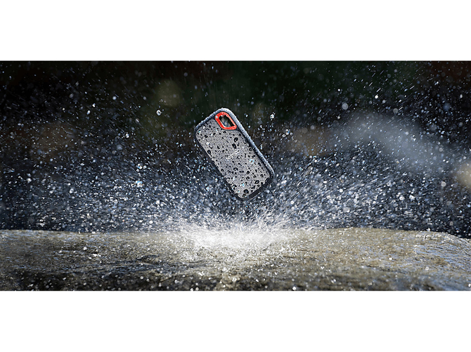 Telefon w etui spryskany wodą, na ciemnym tle.