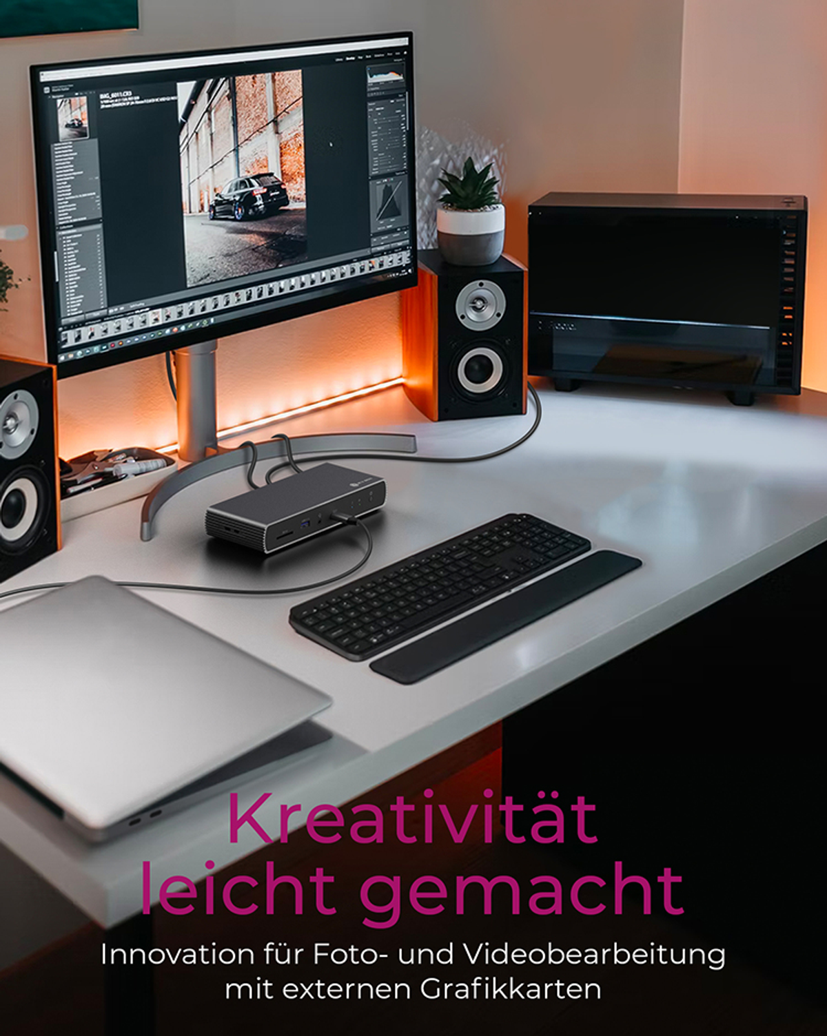 Arbeitsbereich mit Computer, Monitor, Lautsprechern und Tastatur.