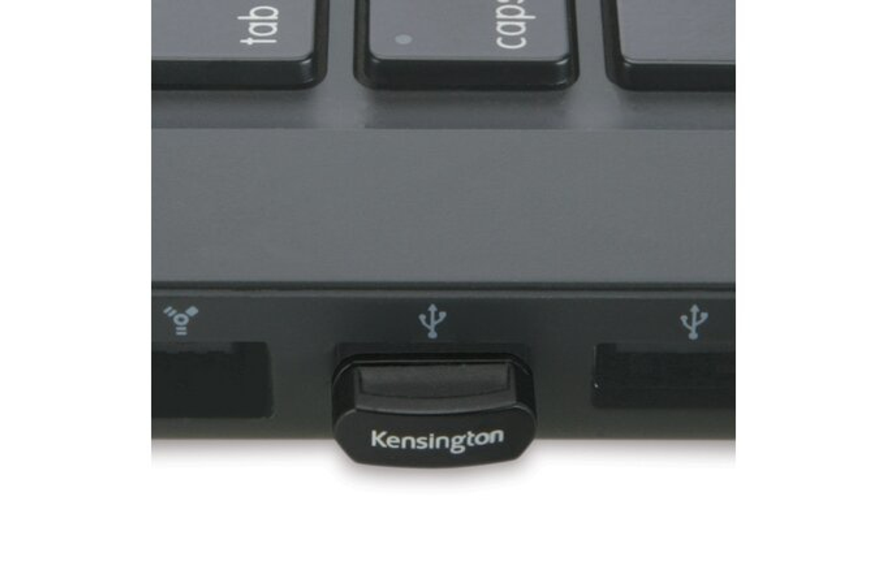 Zwarte Kensington USB-dongle aangesloten op de USB-poort van een laptop. Witte achtergrond.