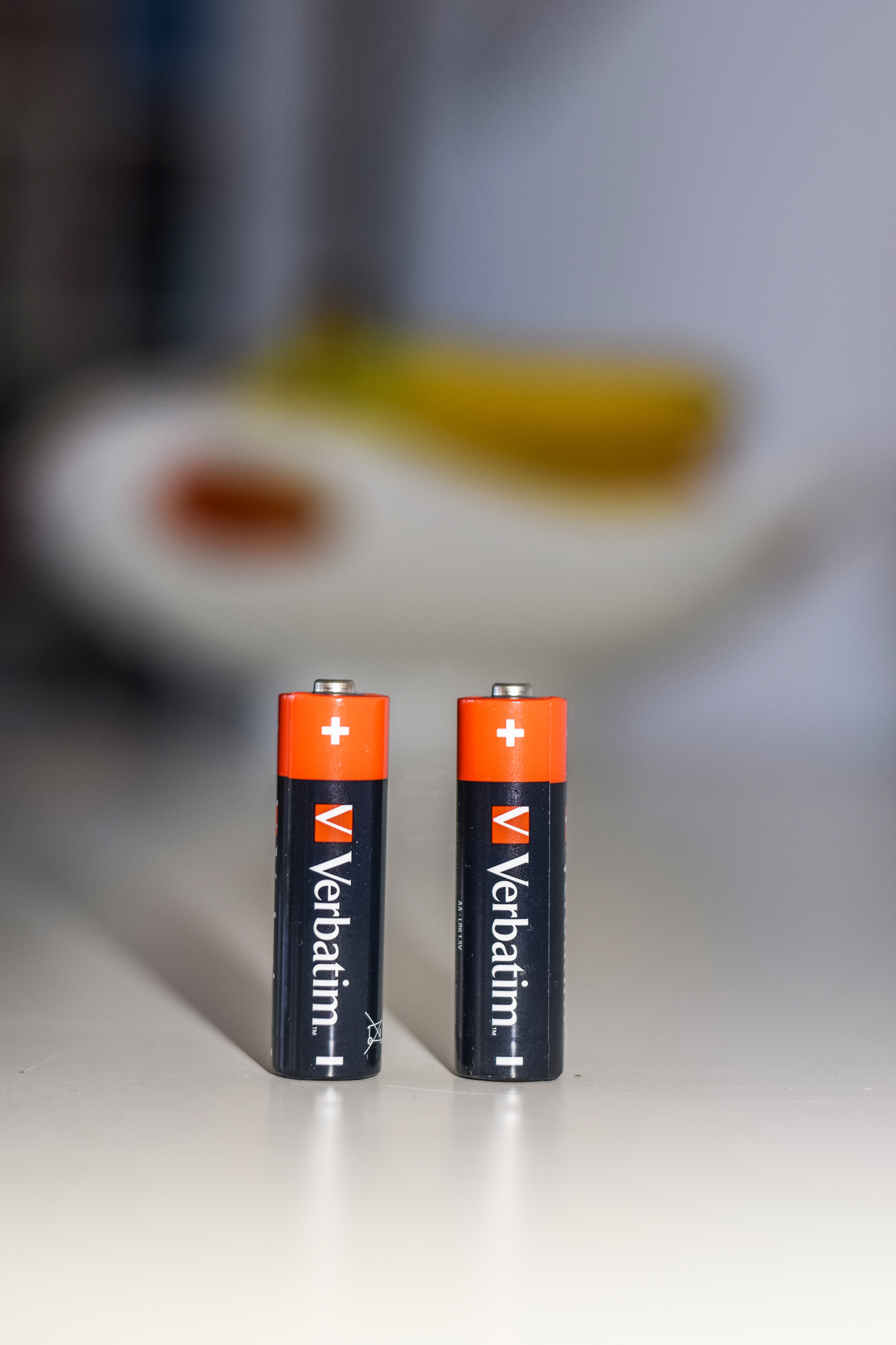 Deux piles AA avec des dessus oranges et des corps noirs.