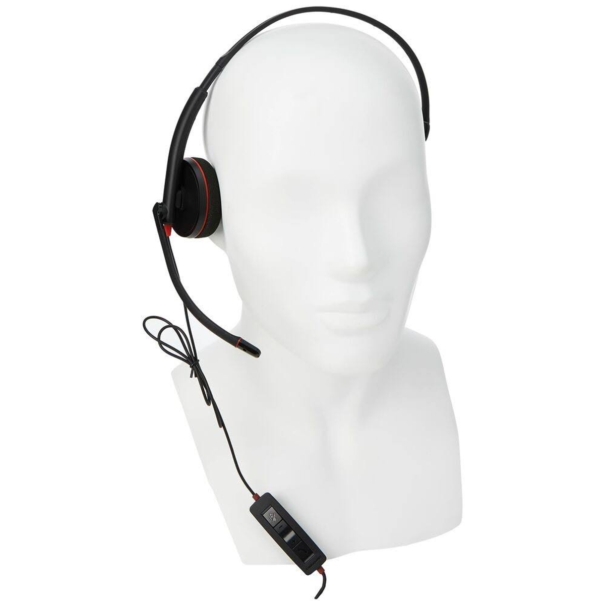 Biała głowa manekina w czarnym zestawie słuchawkowym z czerwonym akcentem.