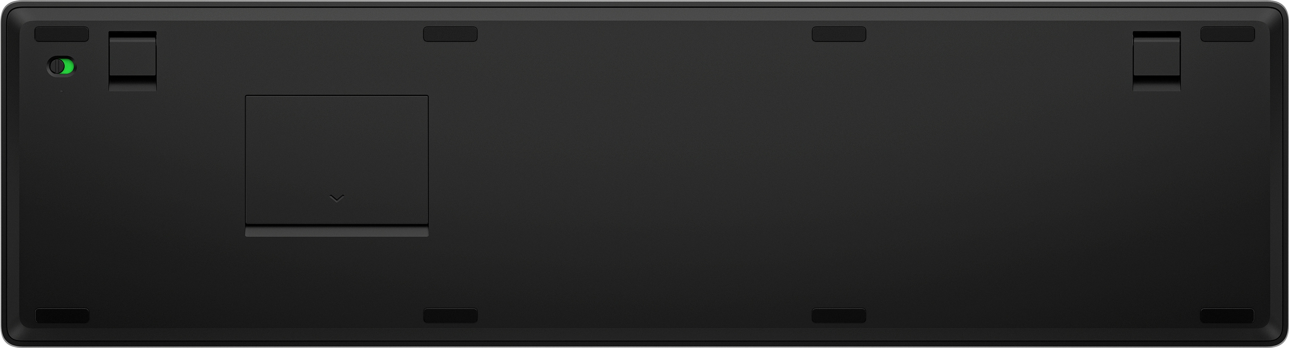 Unterseite einer schwarzen Tastatur. Hat ein Batteriefach und mehrere Gummifüße.