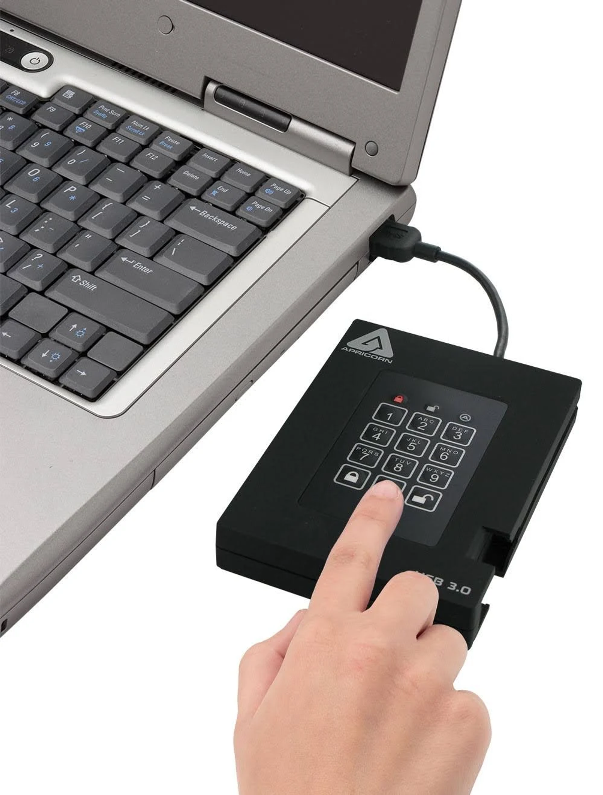 Une main saisit un code PIN sur un appareil USB Apriocorn noir connecté à un ordinateur portable.