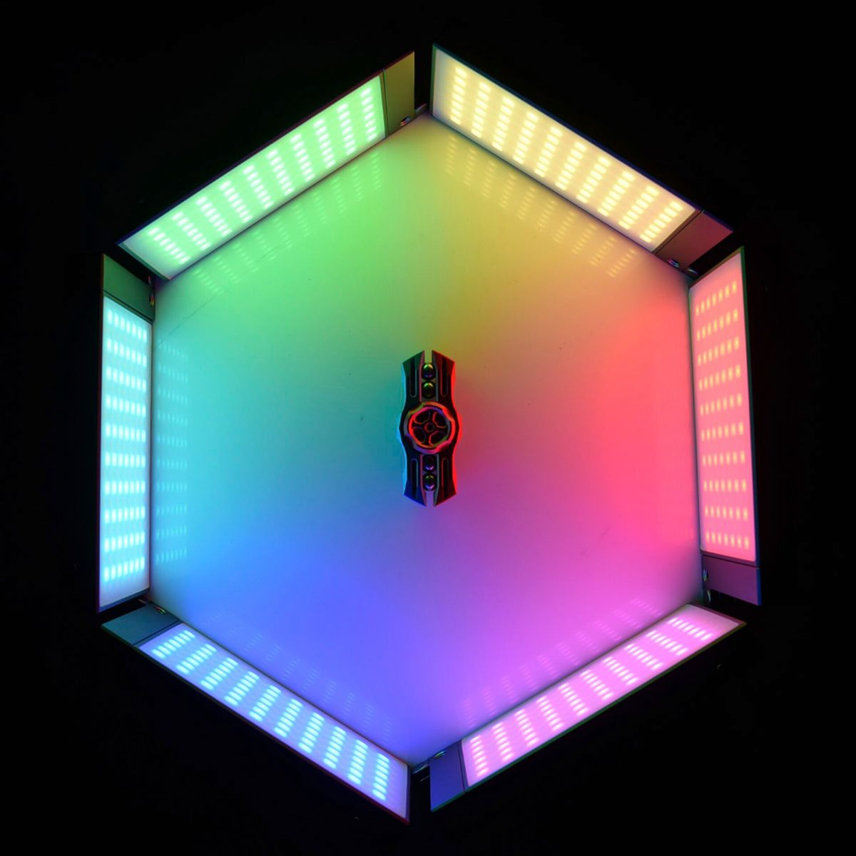 Luminaire hexagonal avec dégradés de couleurs et objet central.