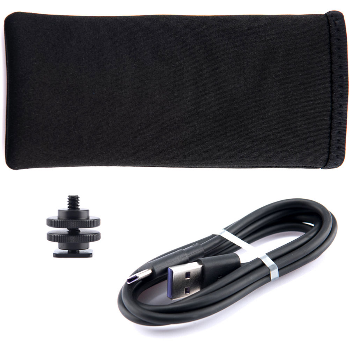 Accessoires noirs : une pochette, une vis et un câble USB. Fond blanc.