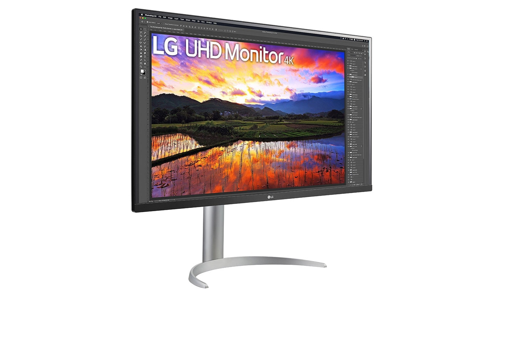 Monitor LG UHD 4K wyświetla obraz krajobrazu. Stoi na srebrnej podstawie na białym tle.