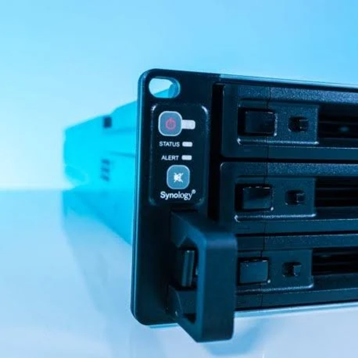 Gros plan de l'avant du serveur. Voyants d'alimentation, d'état et d'alerte. Nom de la marque Synology.