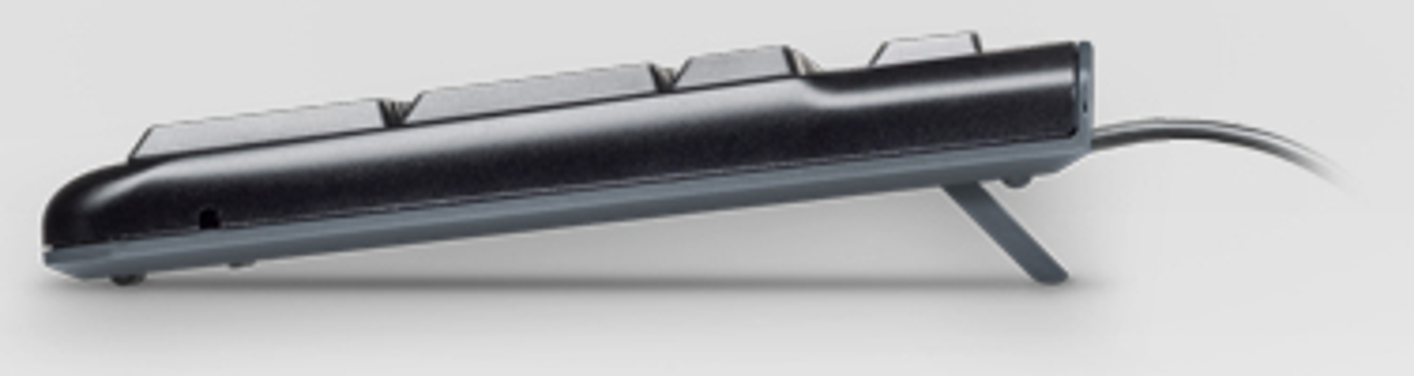 Widok z boku czarnej klawiatury. Pokazuje klawisze i podstawkę z tyłu.