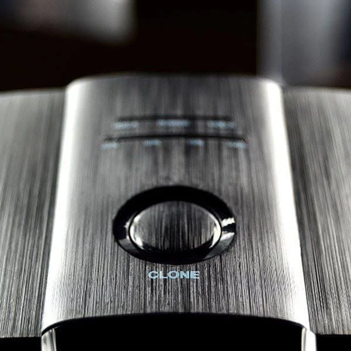 Primo piano di apparecchiature audio con pannello frontale argentato e testo 'CLONE'.