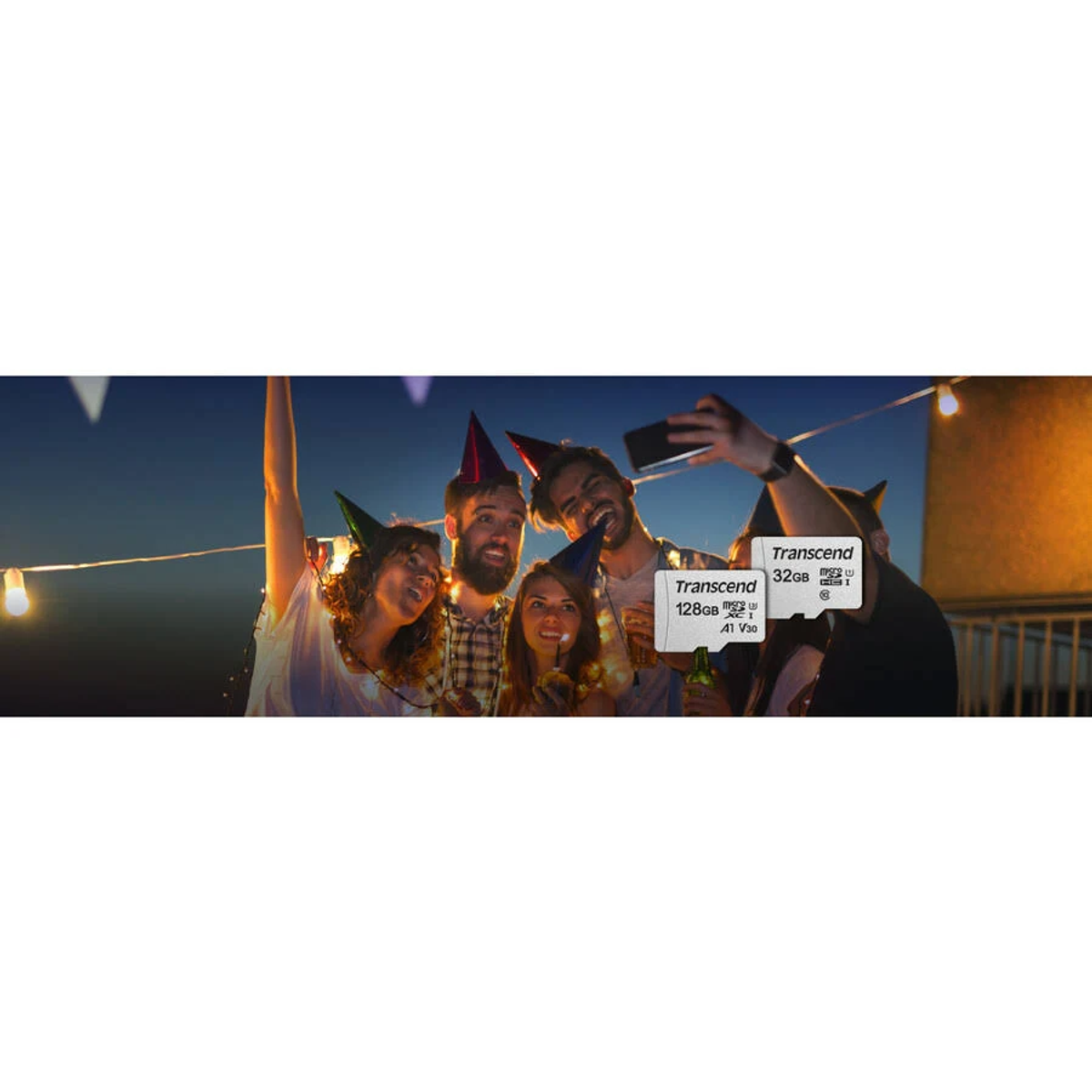 Groep mensen met feesthoeden die een selfie maken met een Transcend SD-kaart, in een nachtelijke setting.