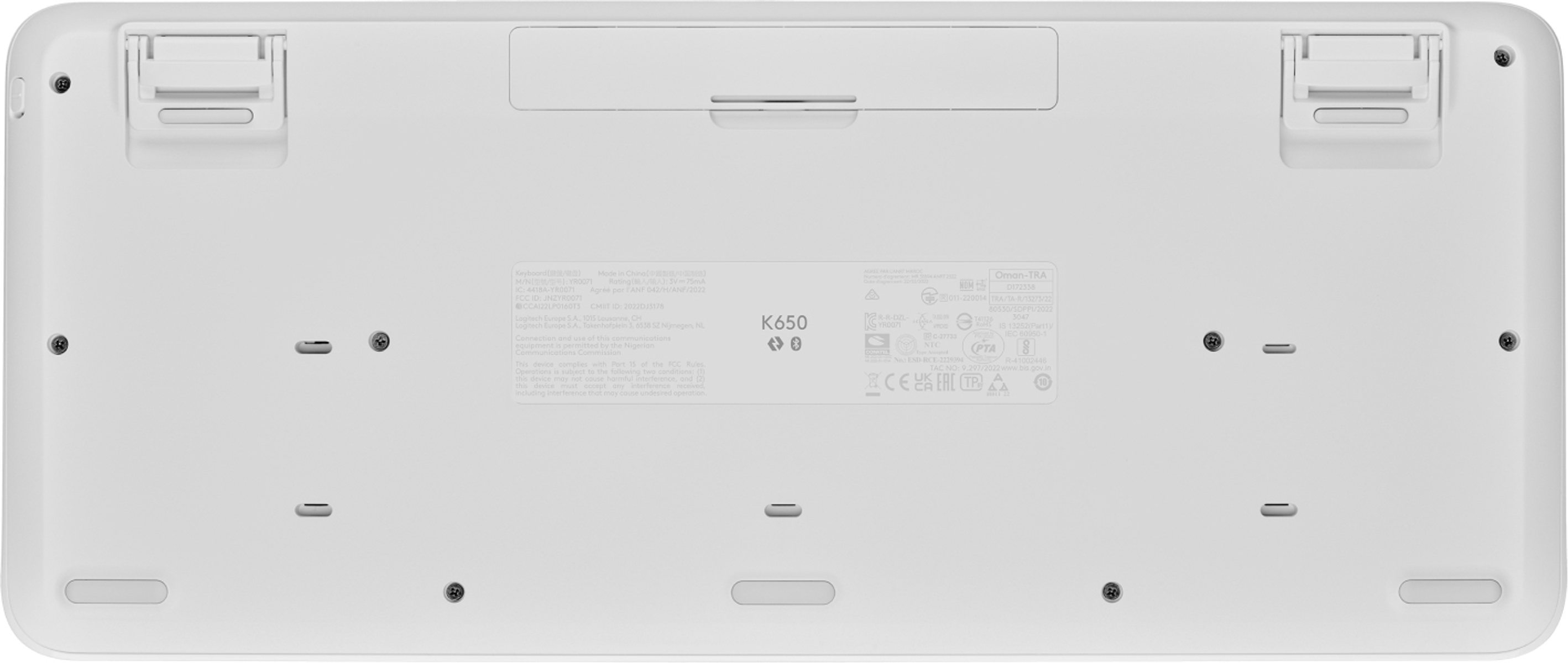 Spód białej klawiatury, z widocznymi śrubami, etykietami i portami.