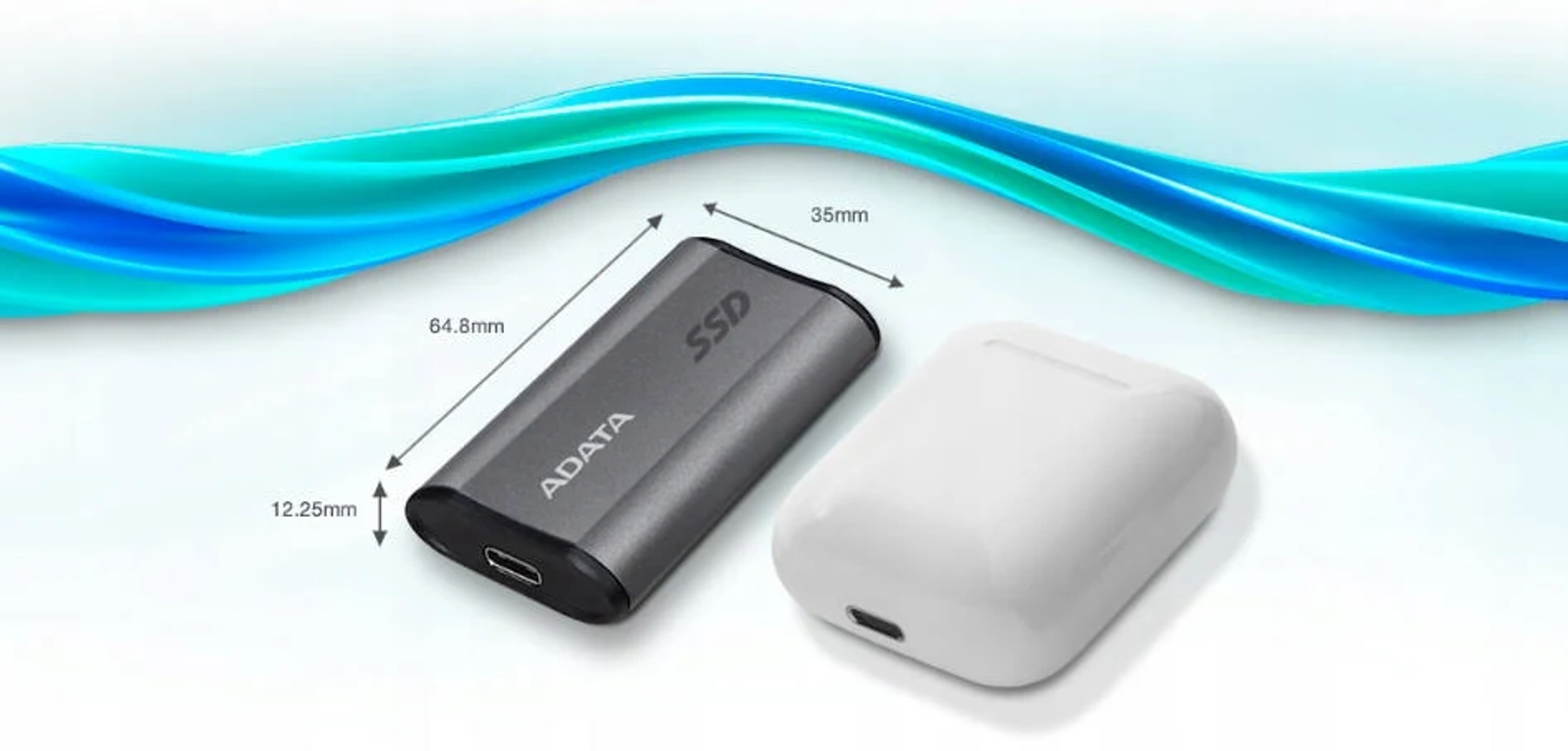 Srebrny i szary przenośny dysk SSD obok białego etui na słuchawki. Wymiary zawarte.