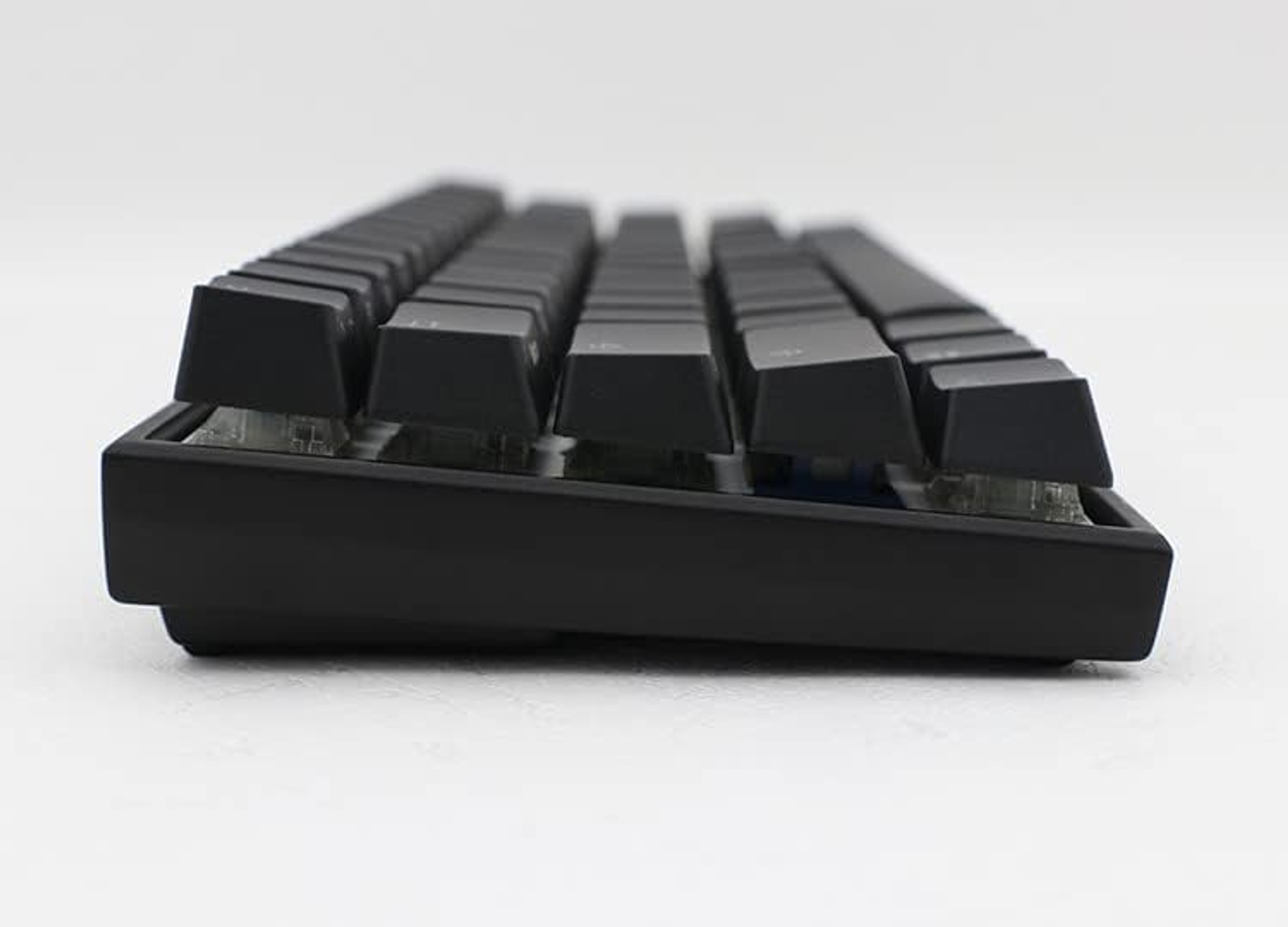 Schwarze Tastatur mit schwarzen Tasten, Schrägansicht, weißer Hintergrund.