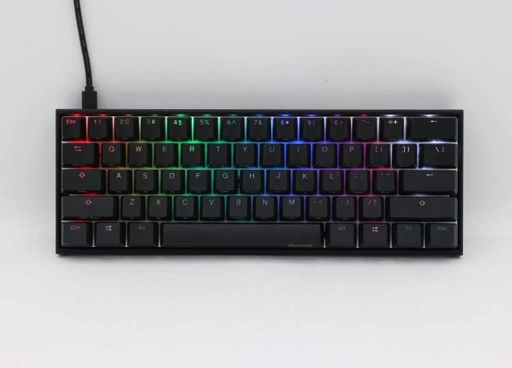 Schwarze 60% mechanische Tastatur mit Regenbogen-Hintergrundbeleuchtung. Ein schwarzes Kabel ist angebracht.