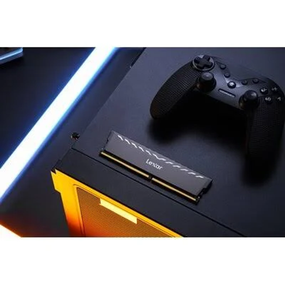Ein schwarzes Computergehäuse mit einem Lexar RAM-Stick und einem schwarzen Gamecontroller oben drauf.