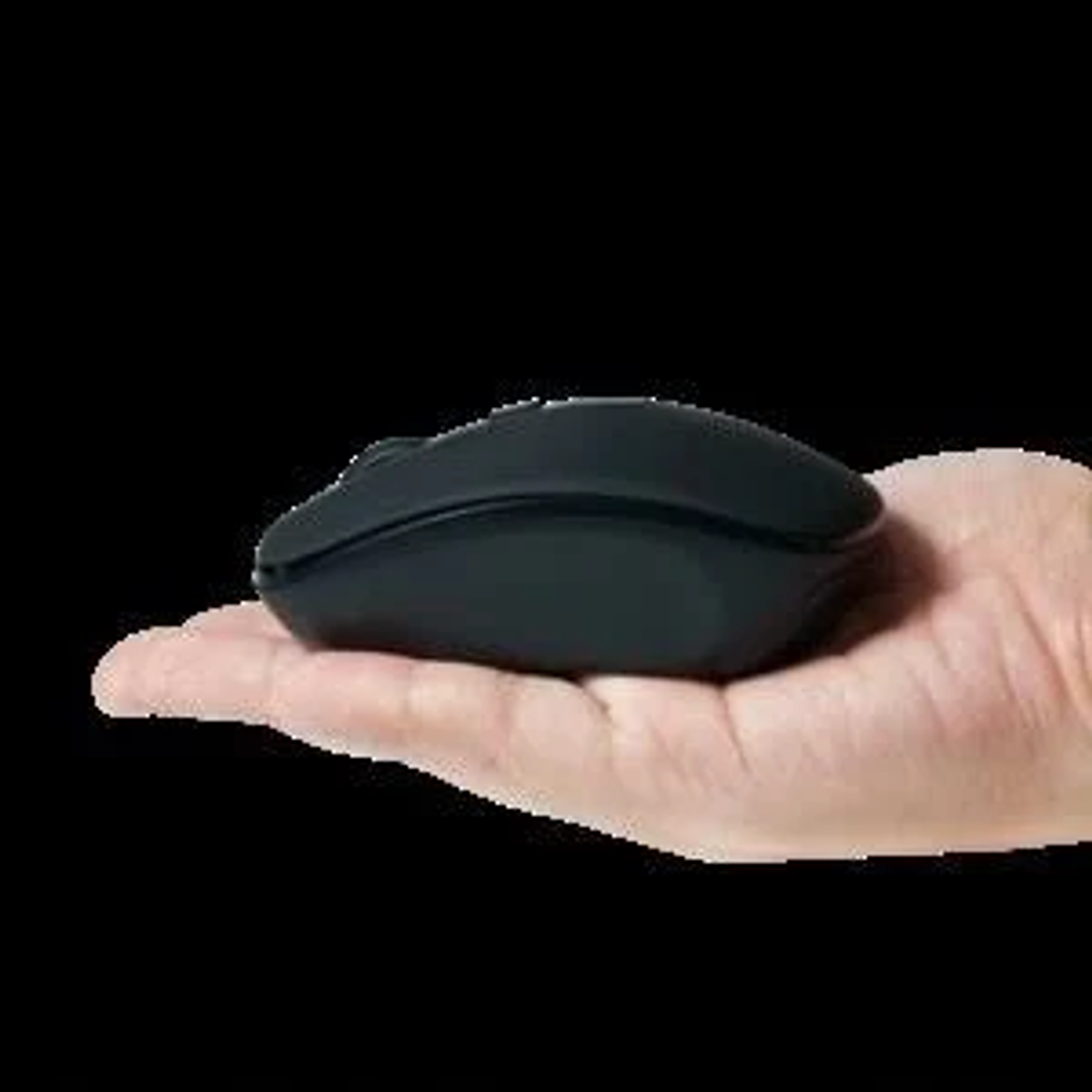 Zwarte computermuis, in een hand gehouden, geïsoleerd op een zwarte achtergrond.